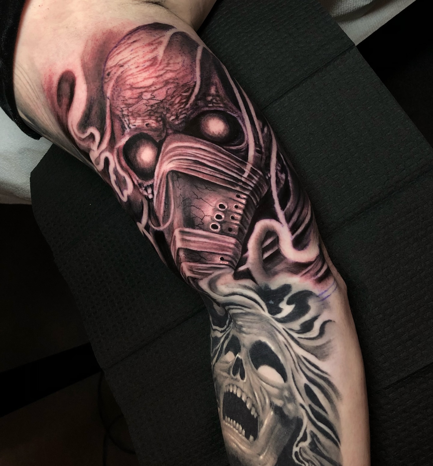 Skull mask dark realism tattoo on the forearm by Corey Ryan
