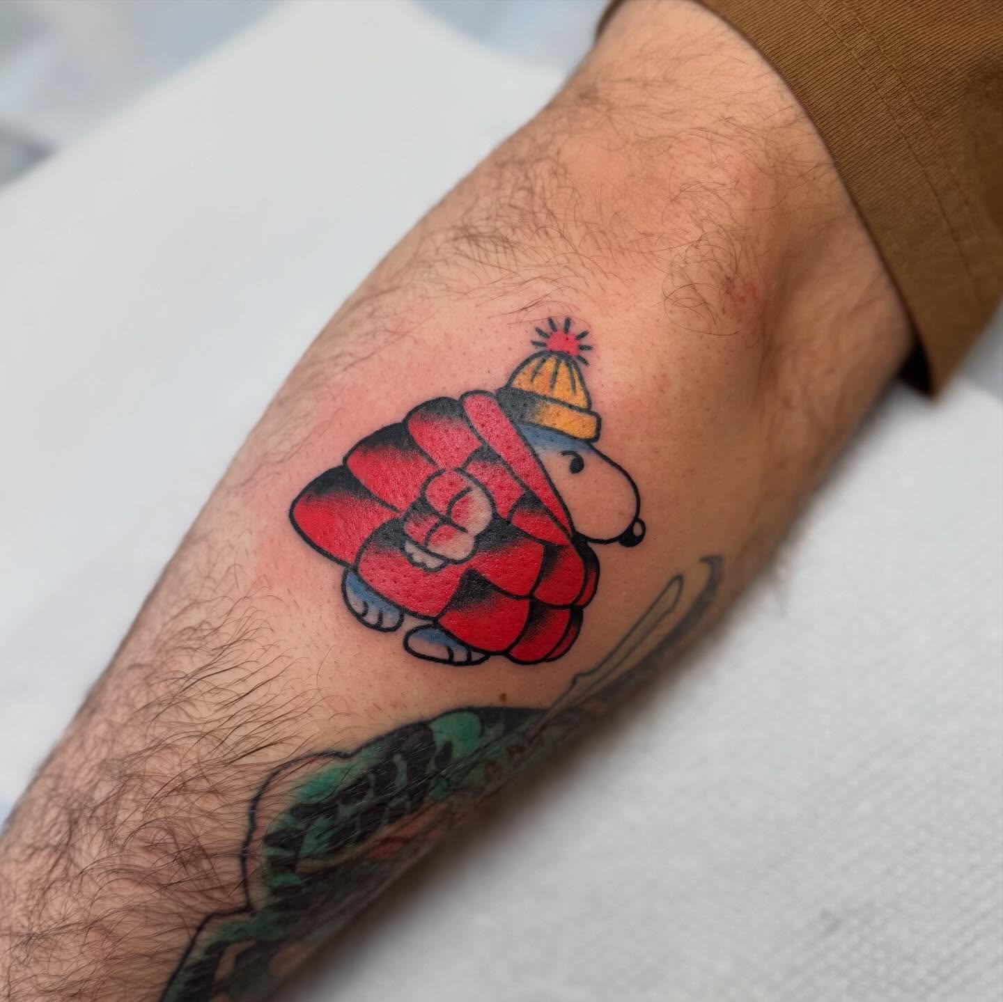Snoopy wearing scarf American traditional tattoo on the forearm by Elle Yax
