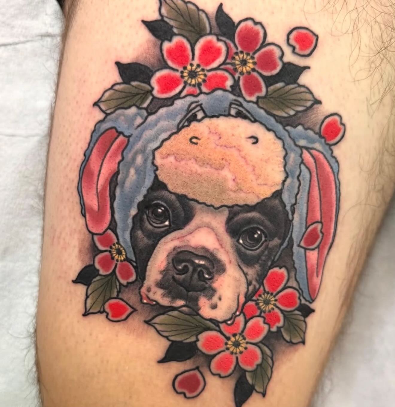 Dog with flower crown American traditional tattoo on the forearm by Kyle Behr