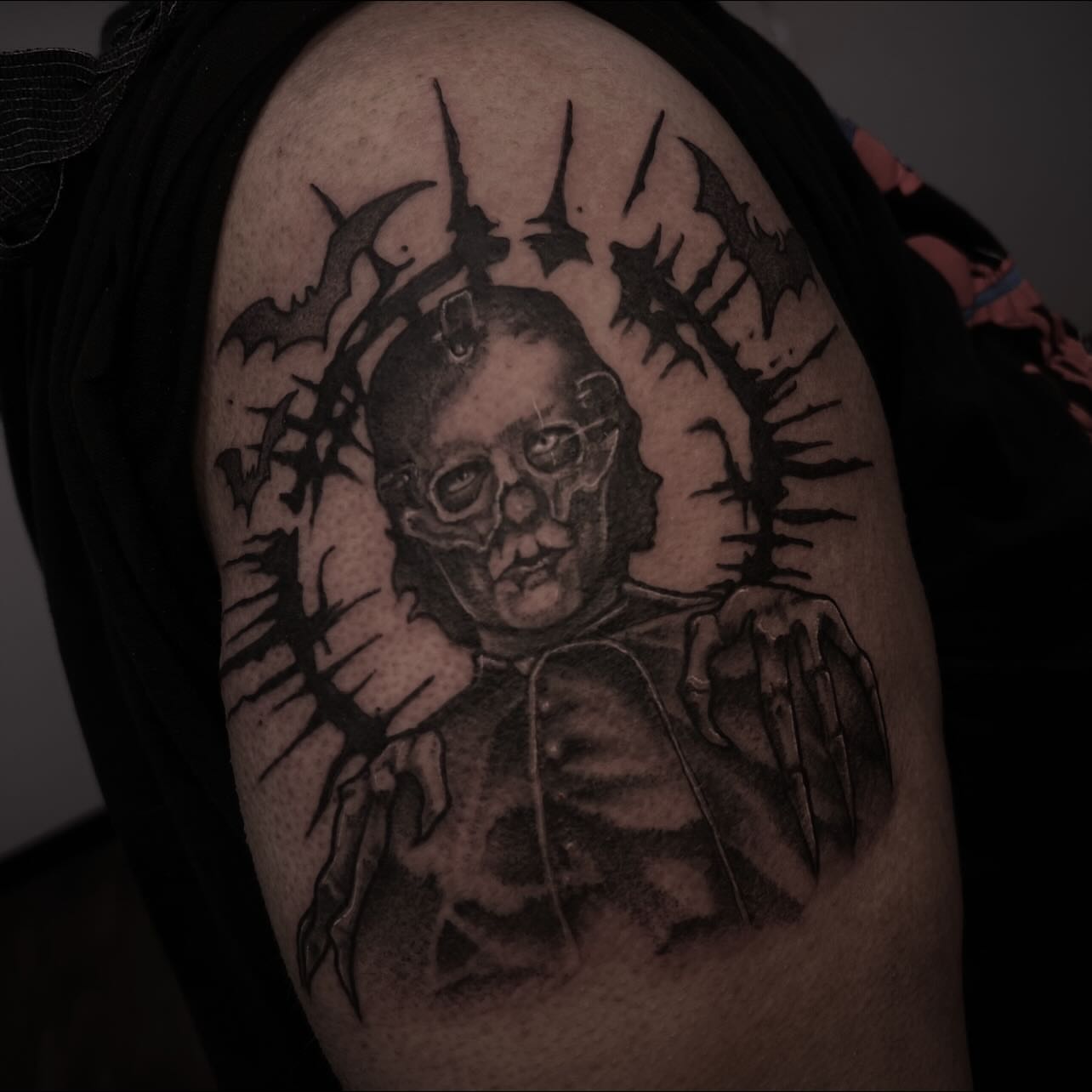 Michael Myers mask black and grey tattoo on the shoulder by Sarah Foltz