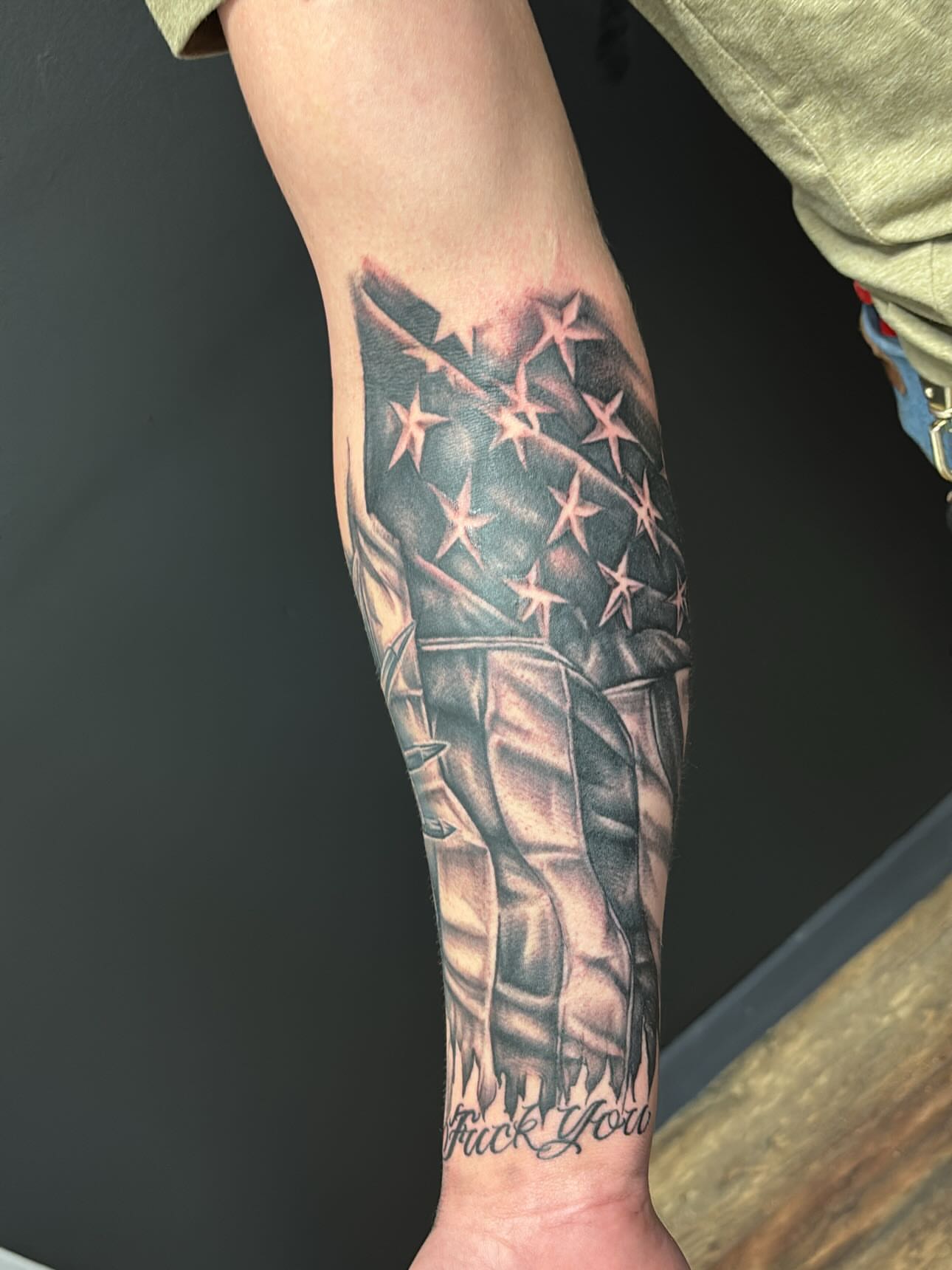 American flag black and grey tattoo on the forearm by Jesus Pubert Munster