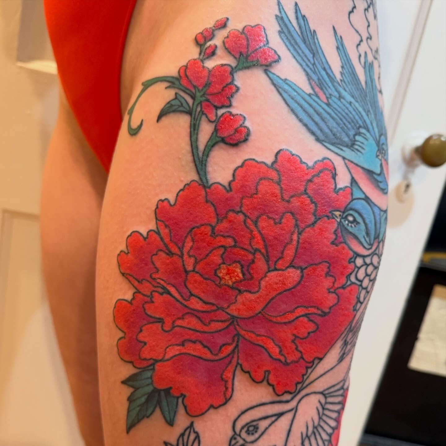 Peony and bird American traditional tattoo on the forearm by Laura Saadati Kepper