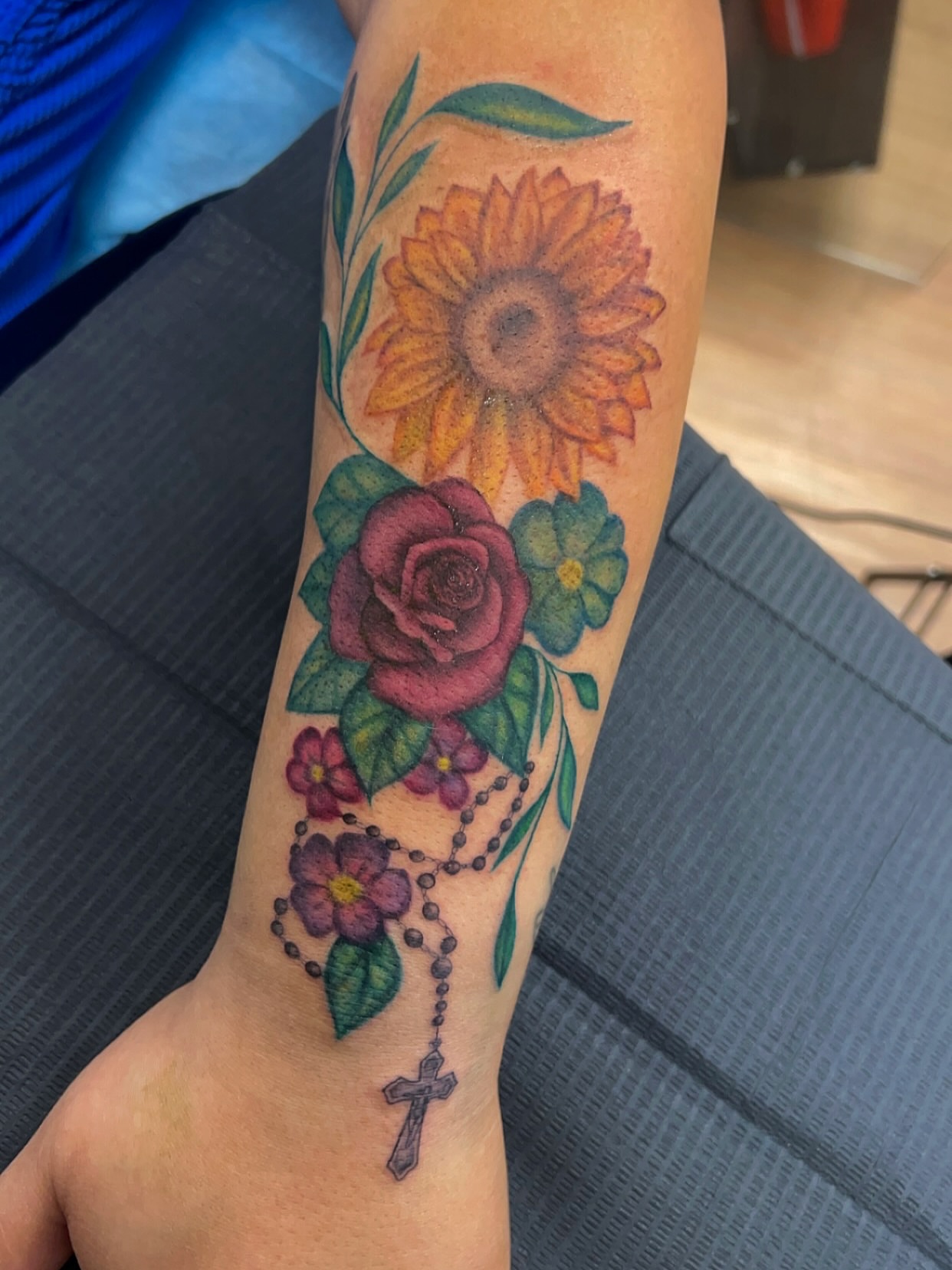 Sunflower and rose realism tattoo on the forearm by Royal Martinez
