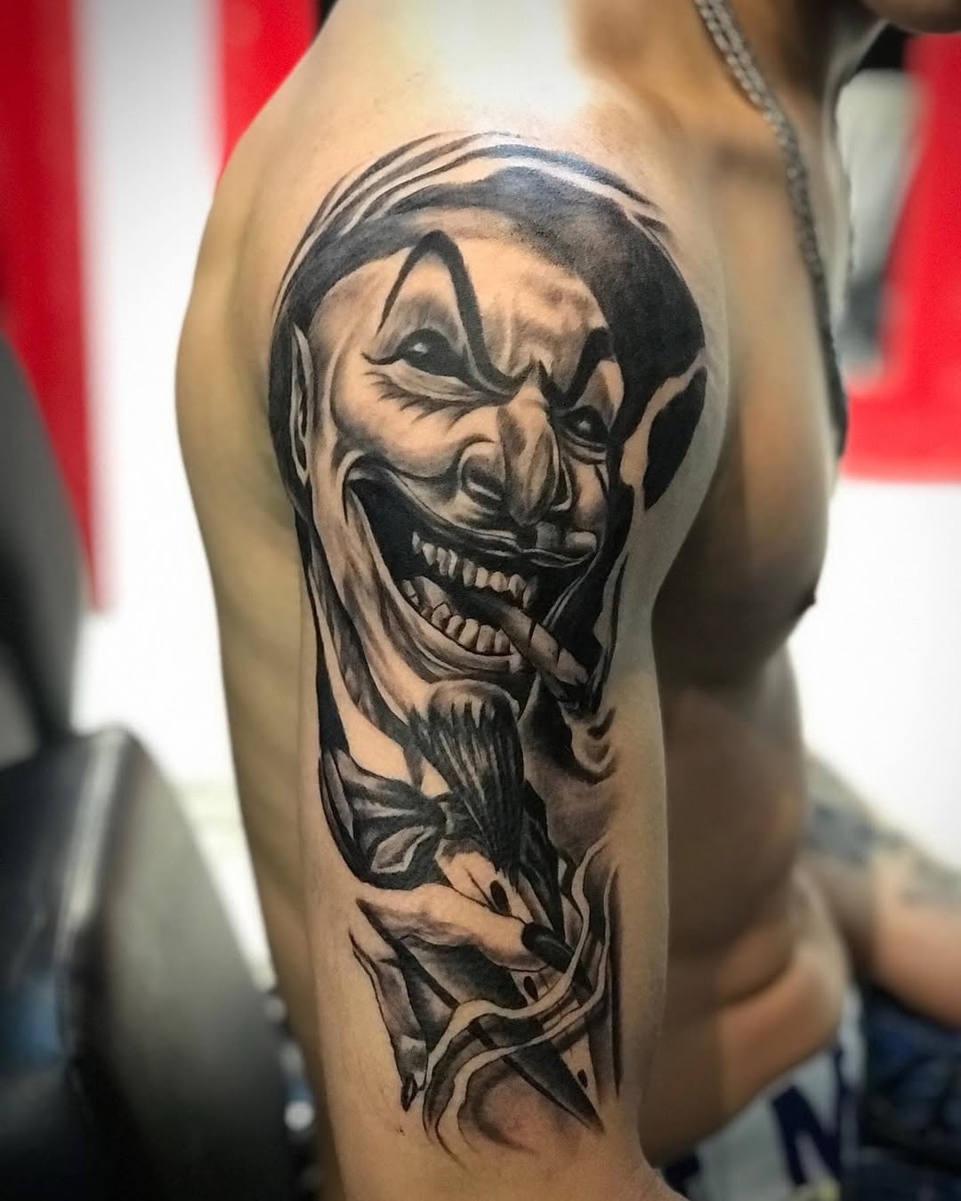 Clown face with cigar realism tattoo on the upper arm by Mauricio gois