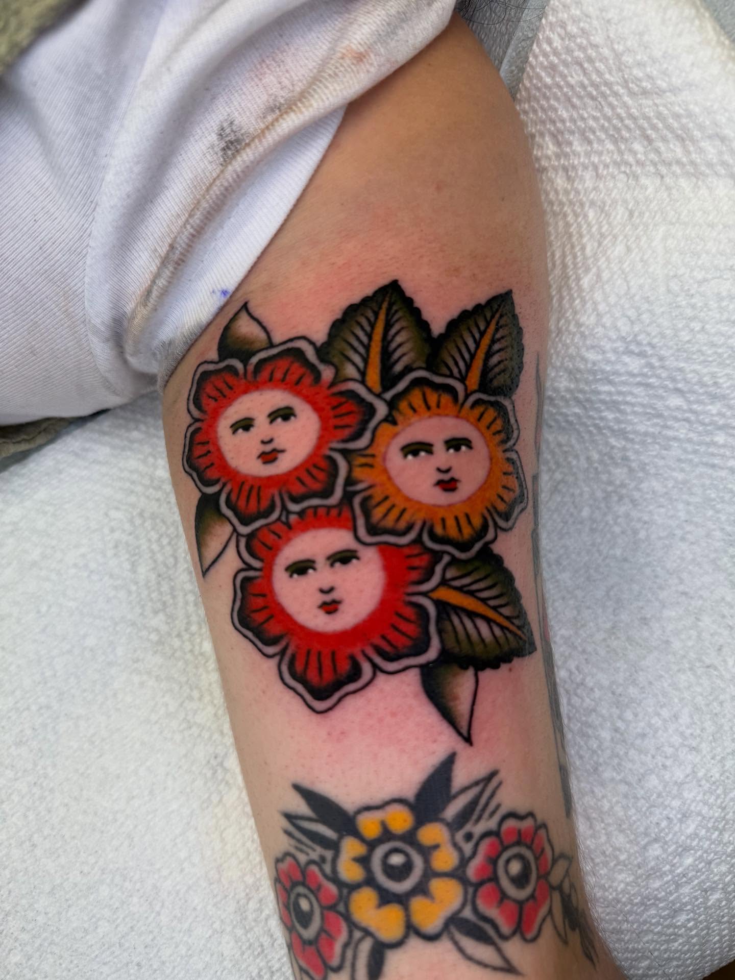 Floral faces American traditional tattoo on the forearm by Cody Petkus