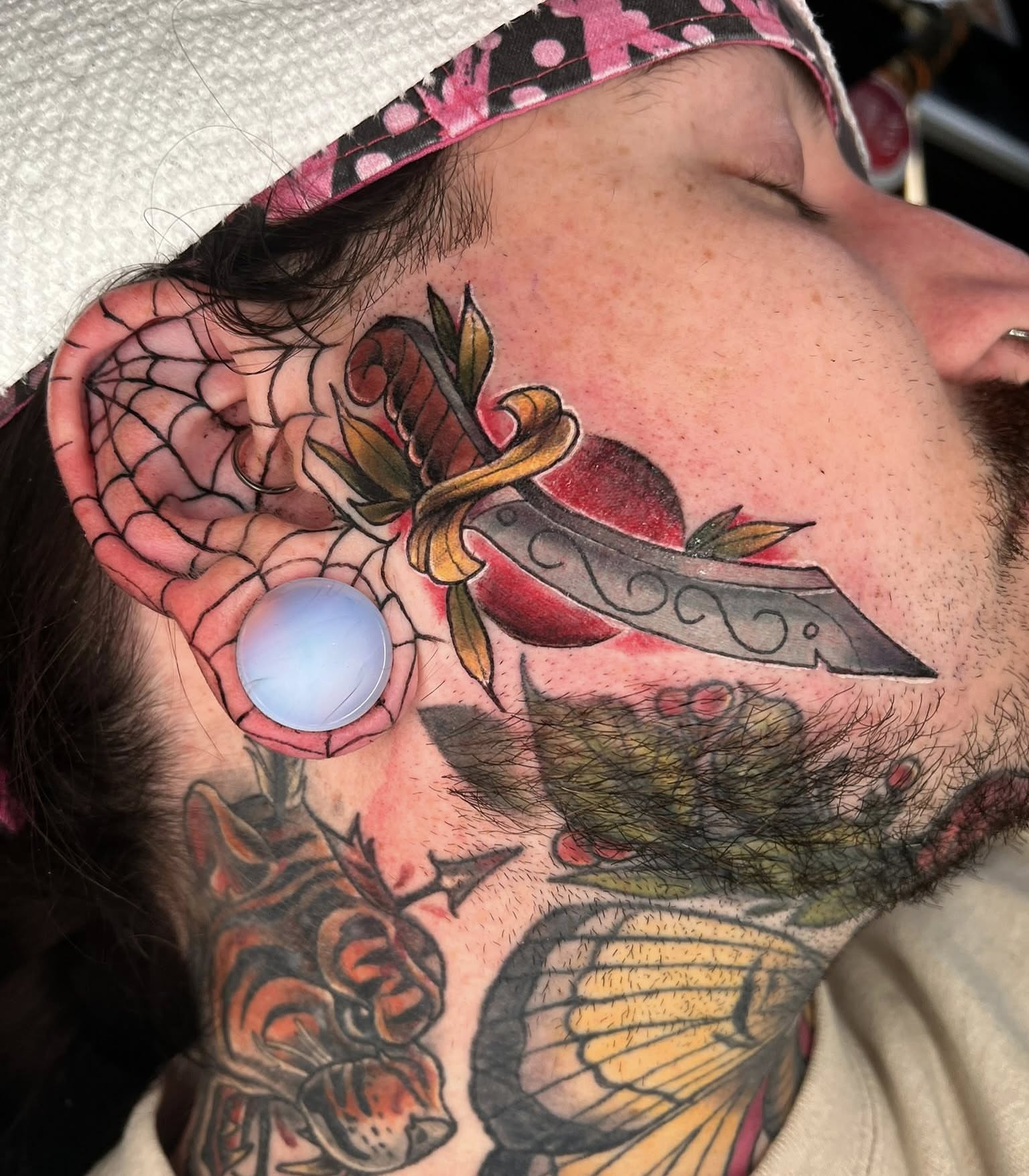 Knife and flower American traditional tattoo on the neck by Brandon Durbin