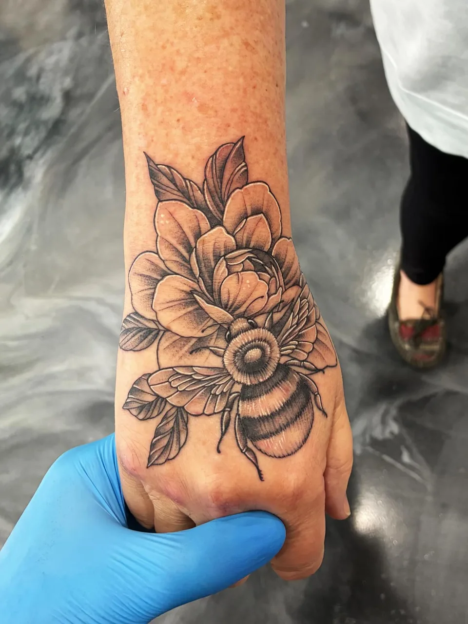 Flower and bee realism tattoo on the forearm by Adam Silfies