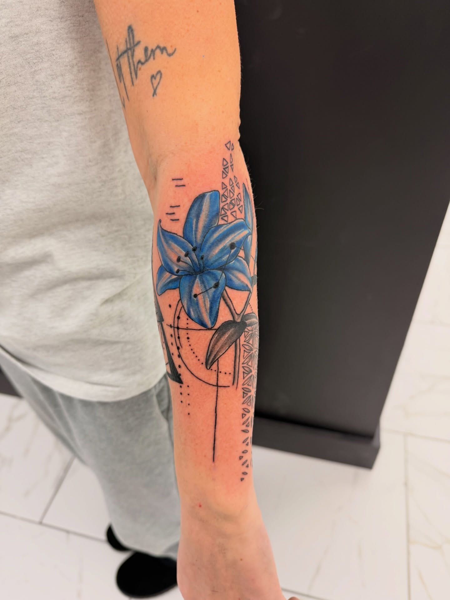 Blue lily dotwork tattoo on the forearm by Lexi Odam