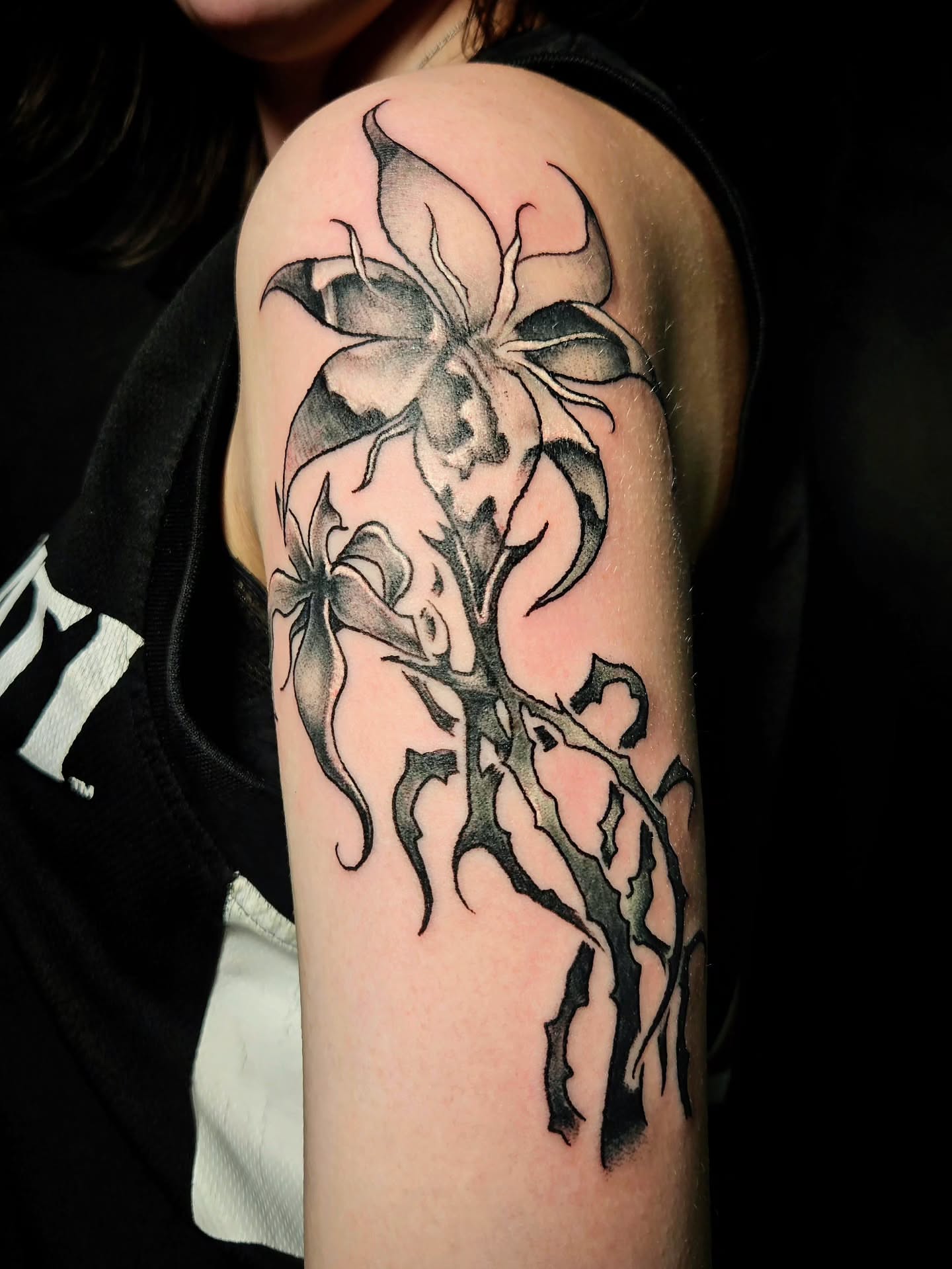 Flower black and grey tattoo on the forearm by Damian Eames