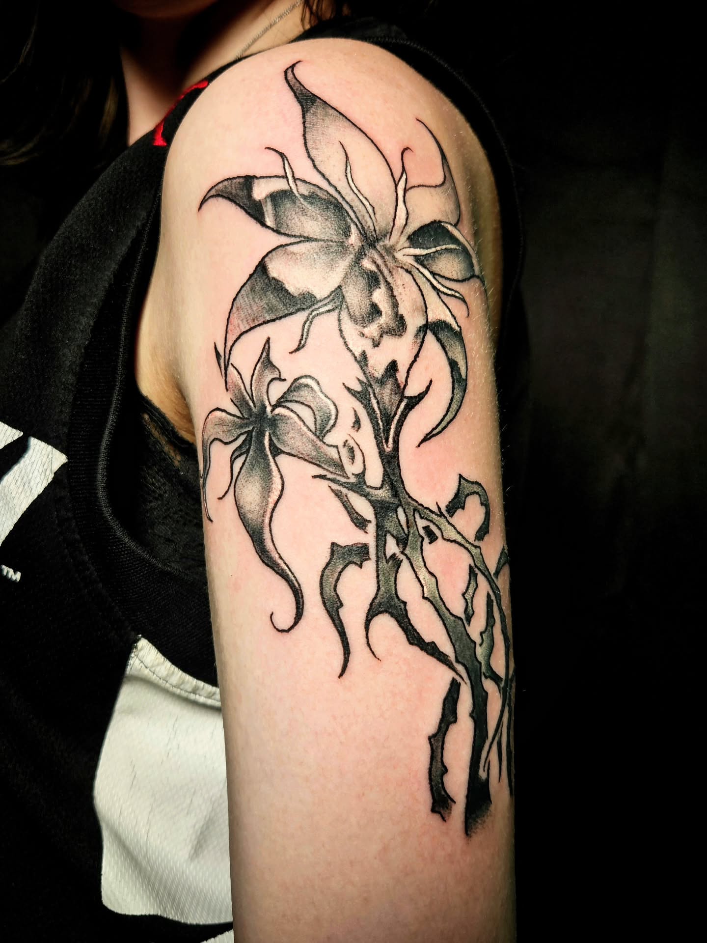 Orchid black and grey tattoo on the forearm by Damian Eames
