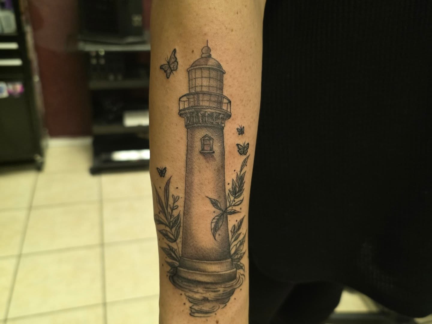 Lighthouse black and grey tattoo on the forearm by Claudia Isabel Roman, El Paso, Texas
