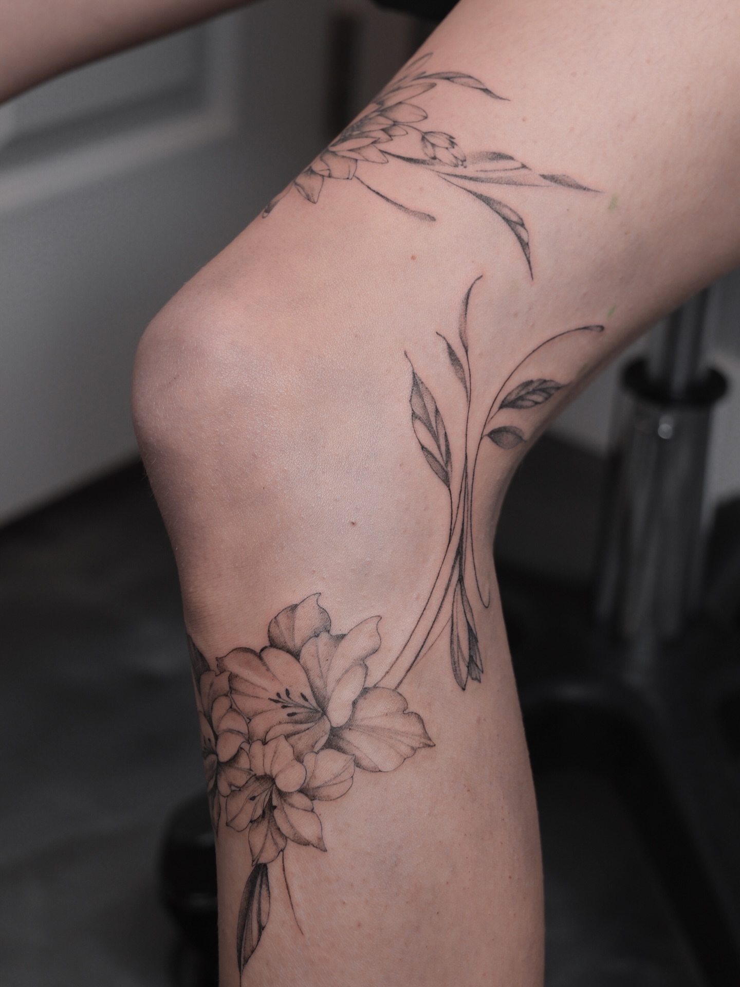 Lily and leaves black and grey tattoo on the forearm by Alina 🌙 Tattoo in Calgary 🇨🇦