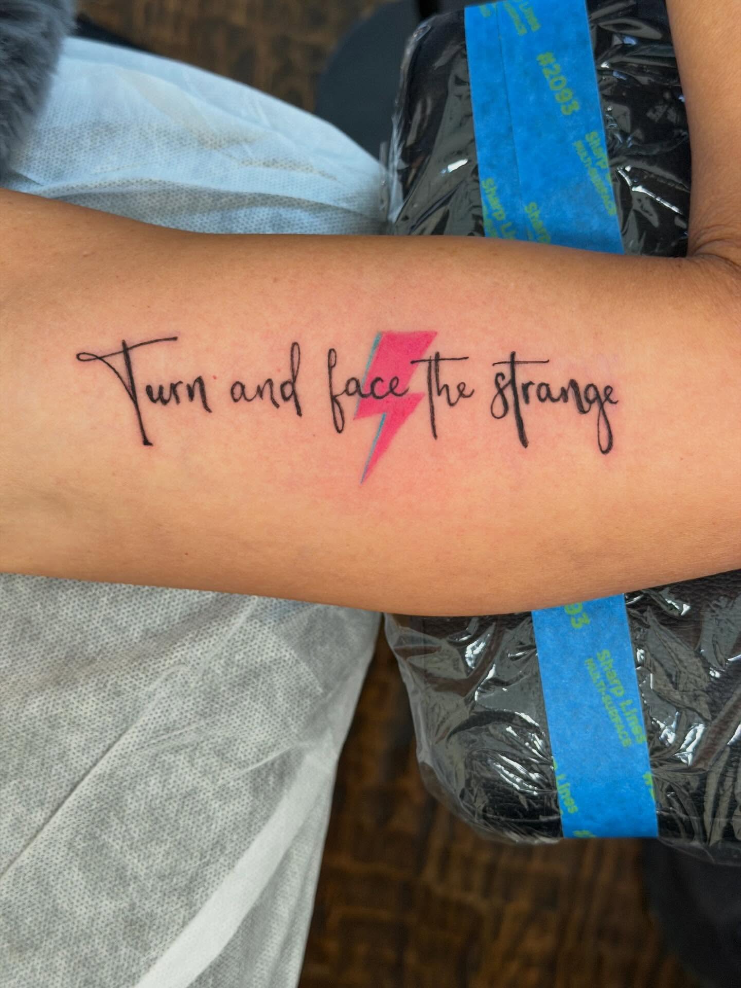 Turn and face the strange lettering script tattoo on the forearm by C.J.K. Roy