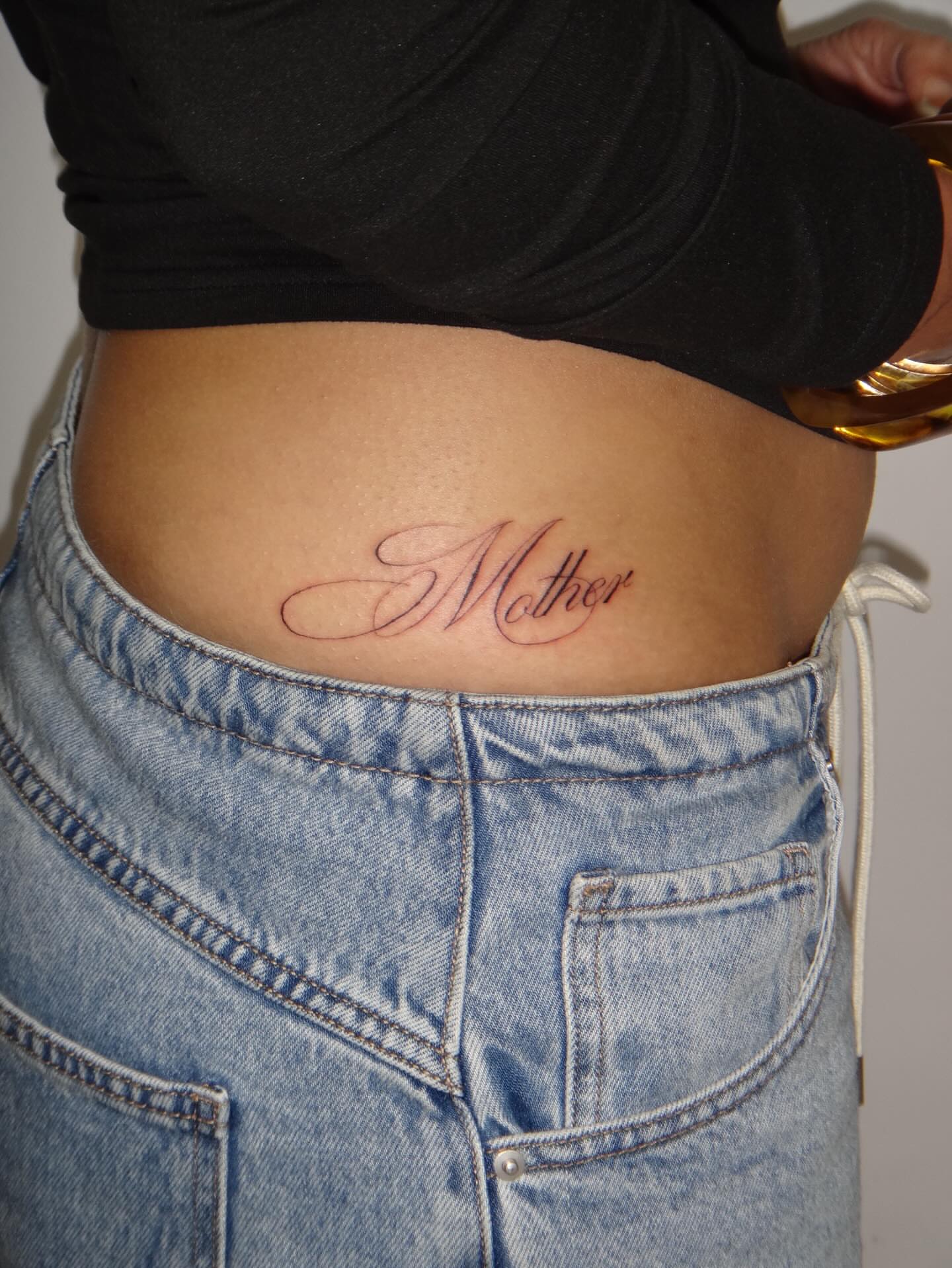 Mother lettering script tattoo on the torso by Nevaeh tattoo artist