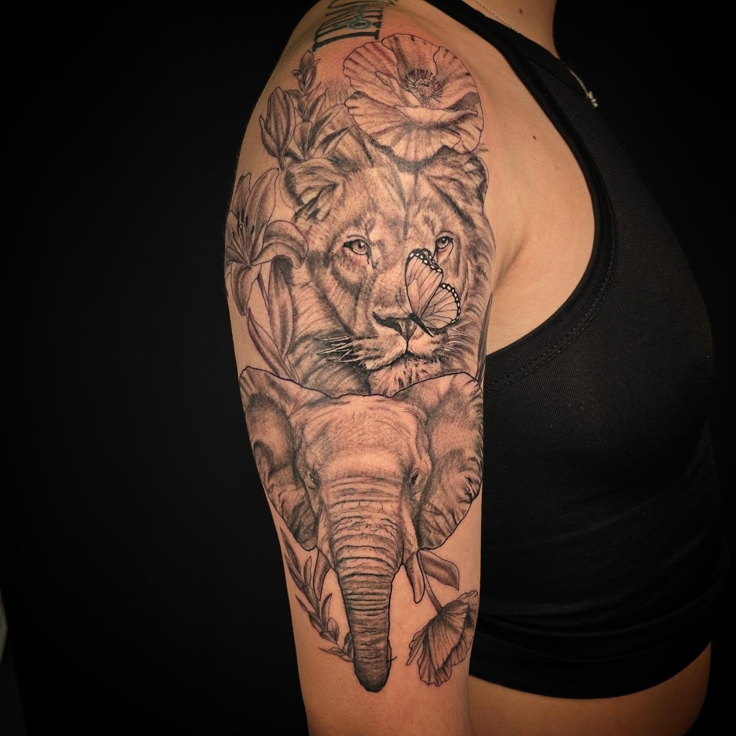 Lion and elephant realism tattoo on the upper arm by Linda Marroum, Morningside, Maryland
