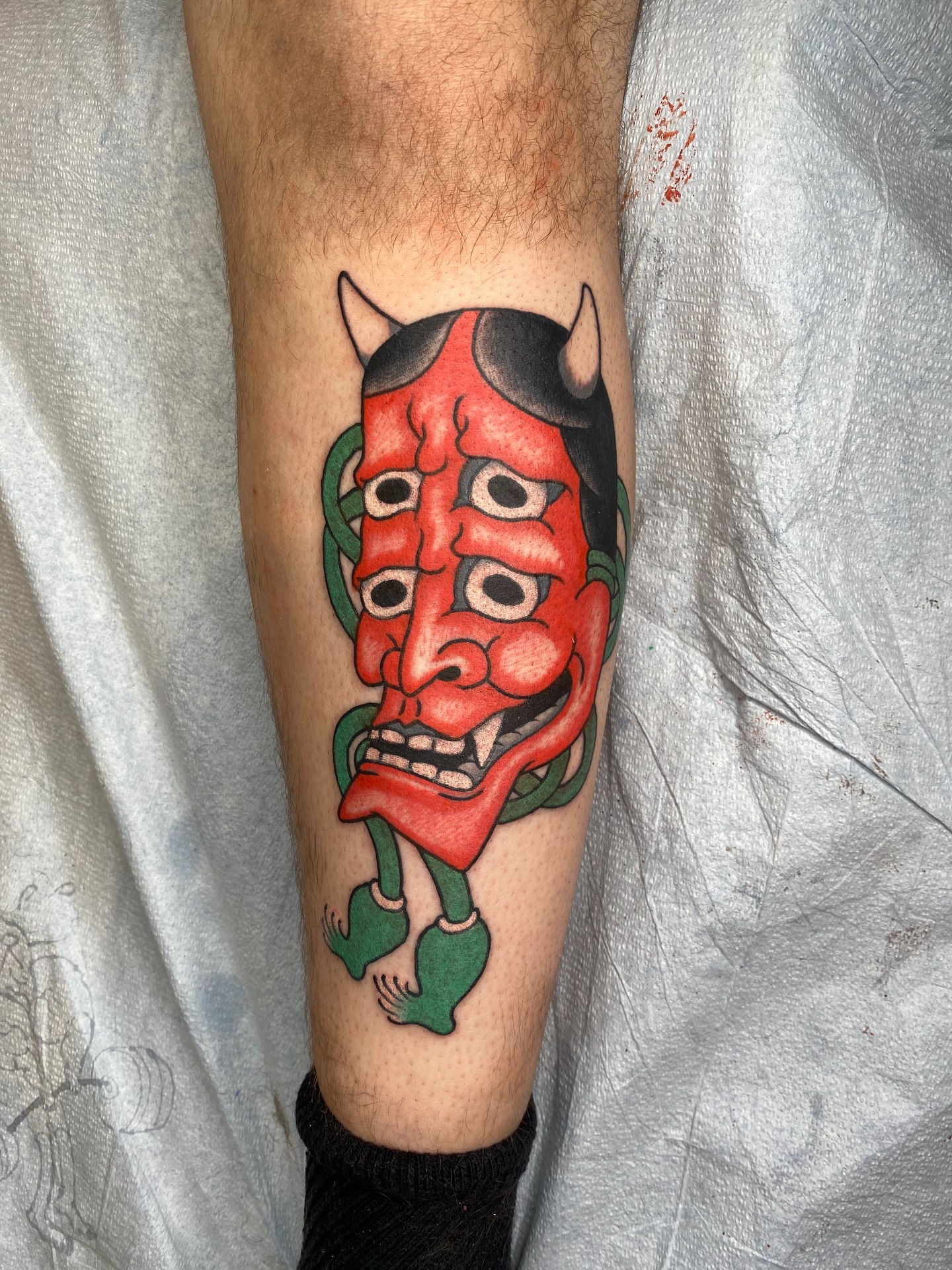 Demon mask American traditional tattoo on the forearm by Mike "Yogi" Trube