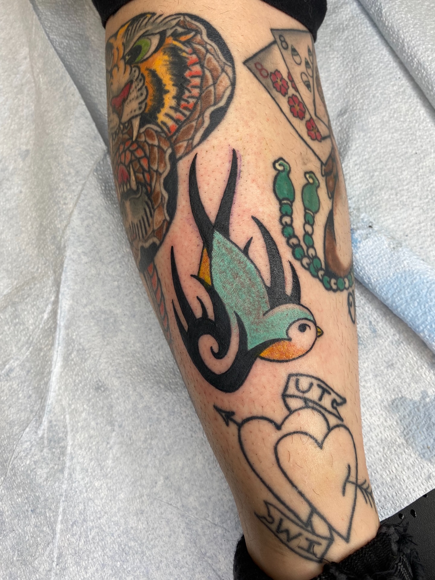 Bird and heart American traditional tattoo on the forearm by Mike "Yogi" Trube