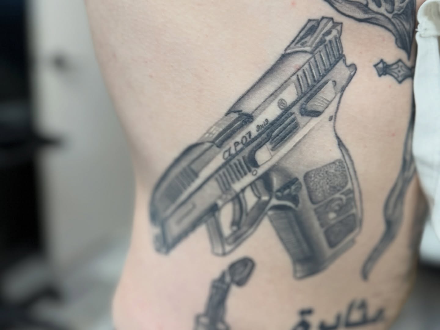 Gun black and grey tattoo on the ribs by Atlanta Tattoo Artist