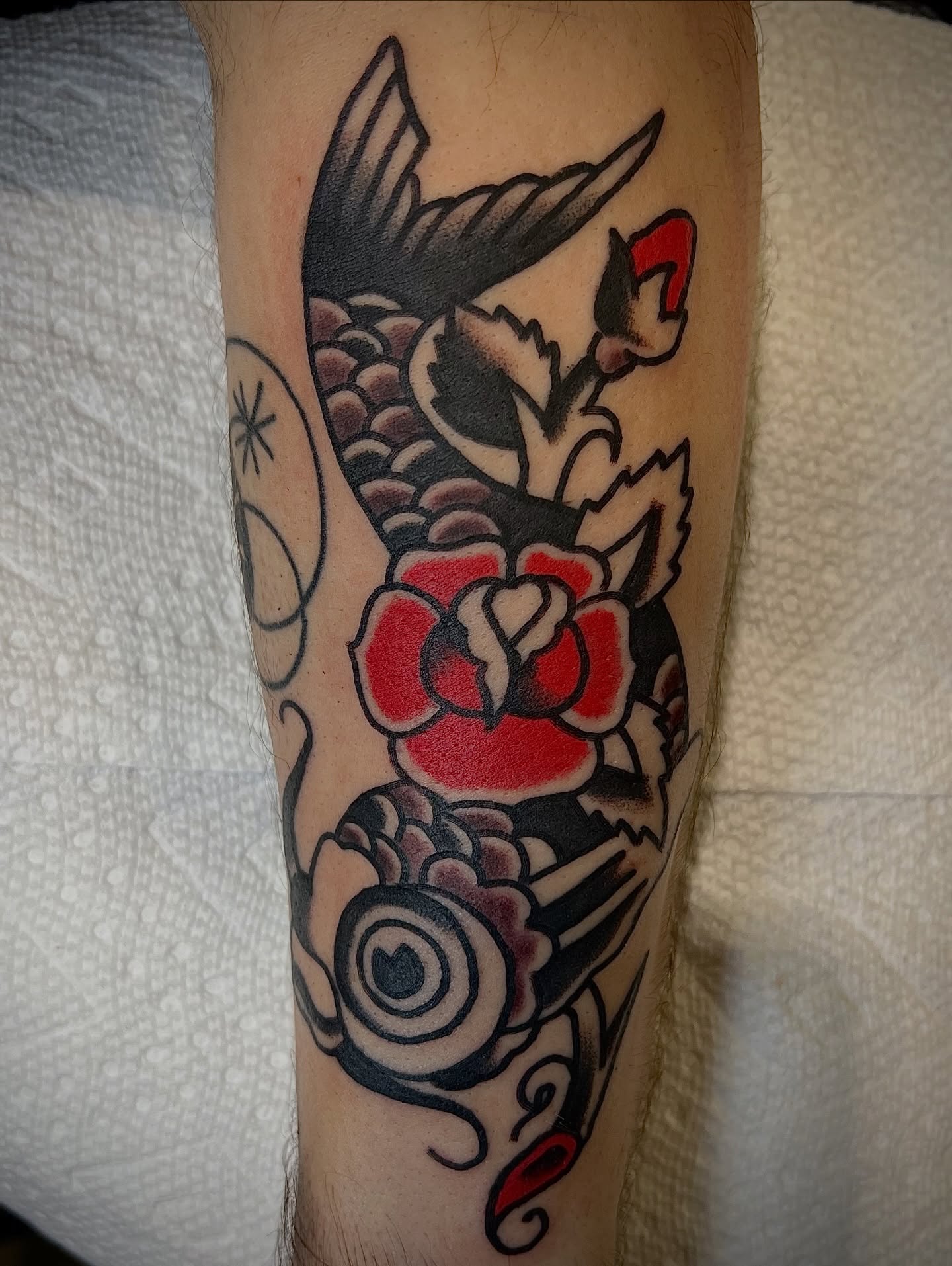 Koi fish and roses American traditional tattoo on the forearm by Nestor Zelaya