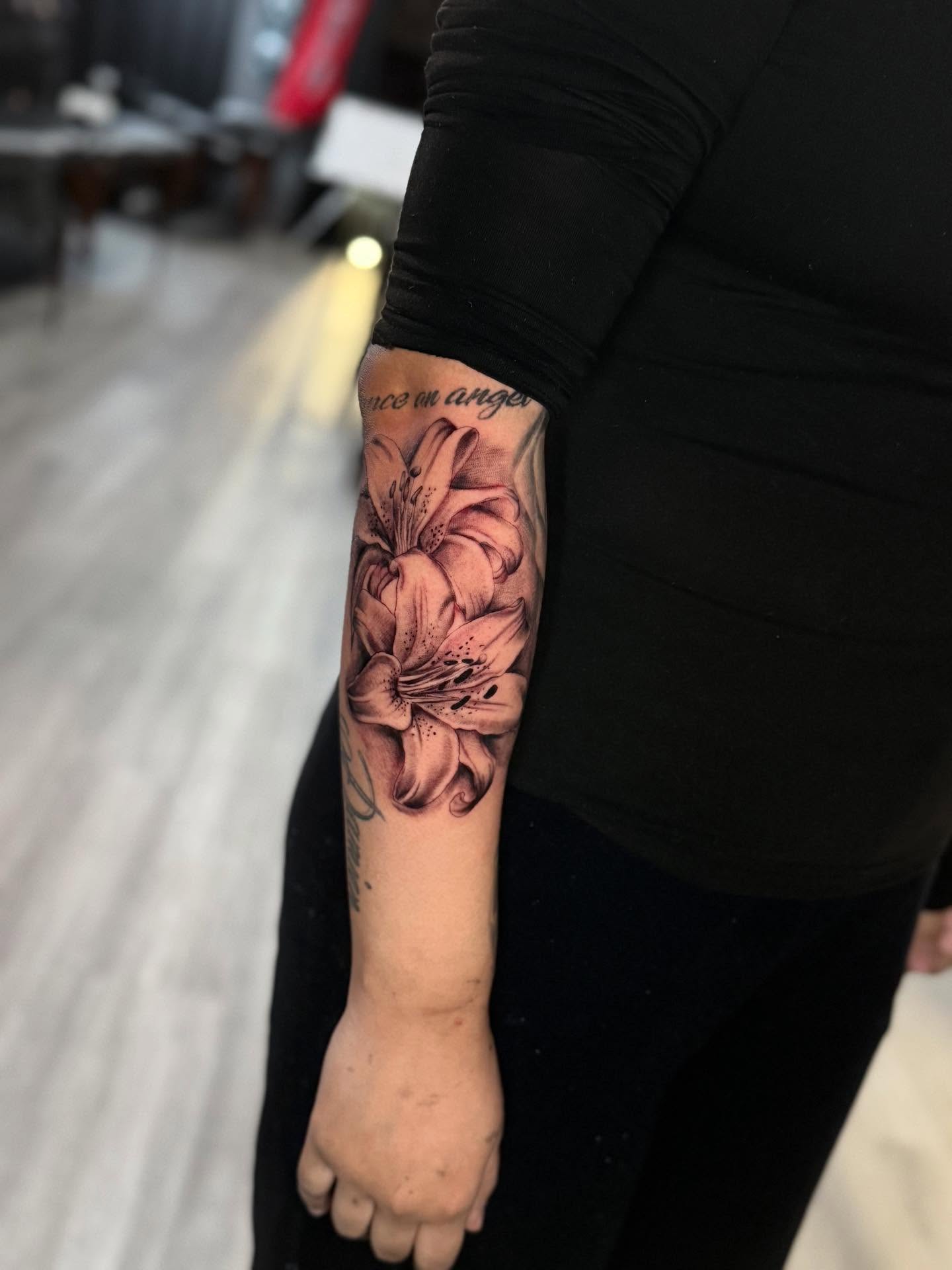 Lily realism tattoo on the forearm by Adrián Banuelos