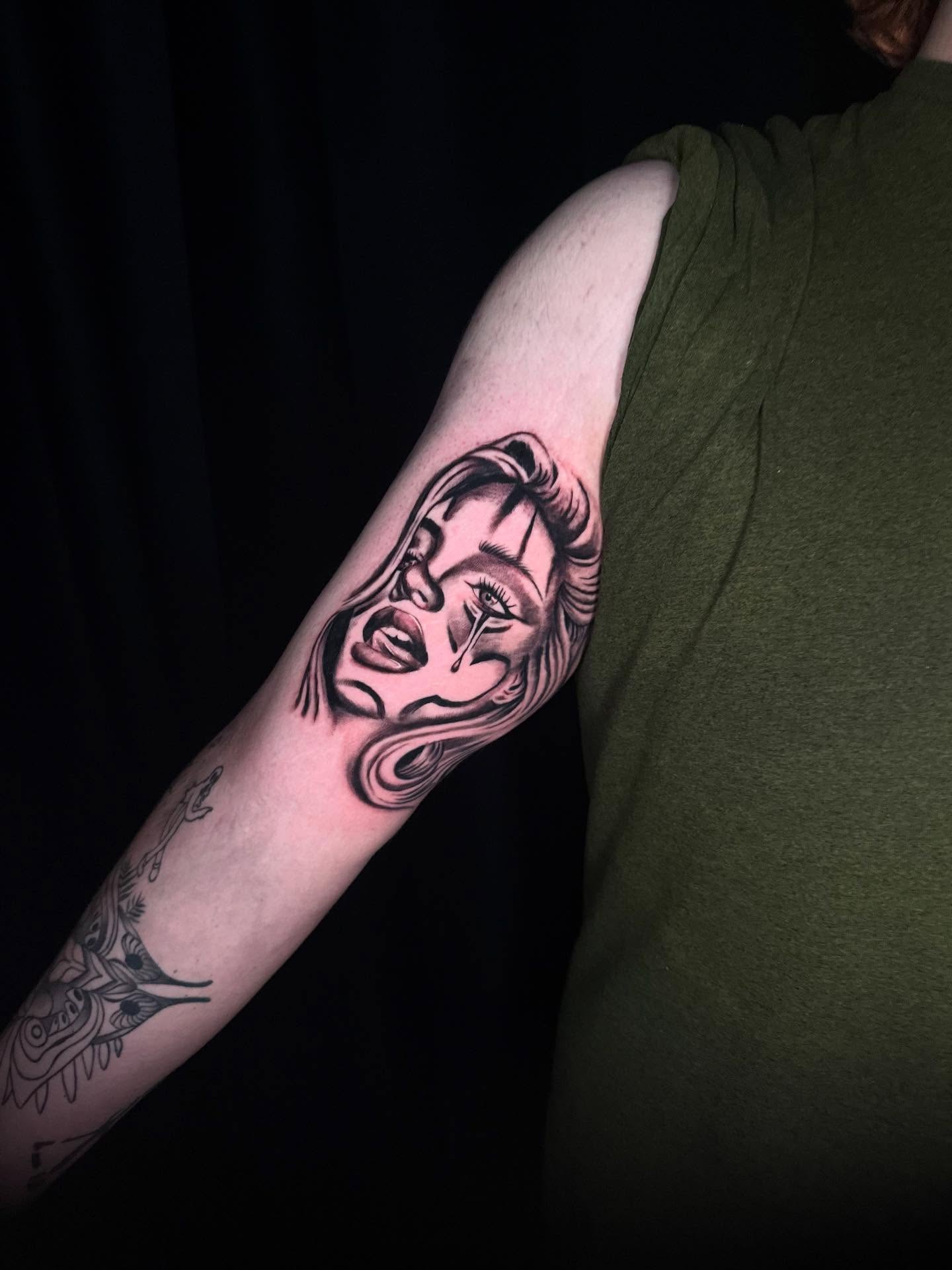 Woman's face black and grey tattoo on the forearm by Adrián Banuelos