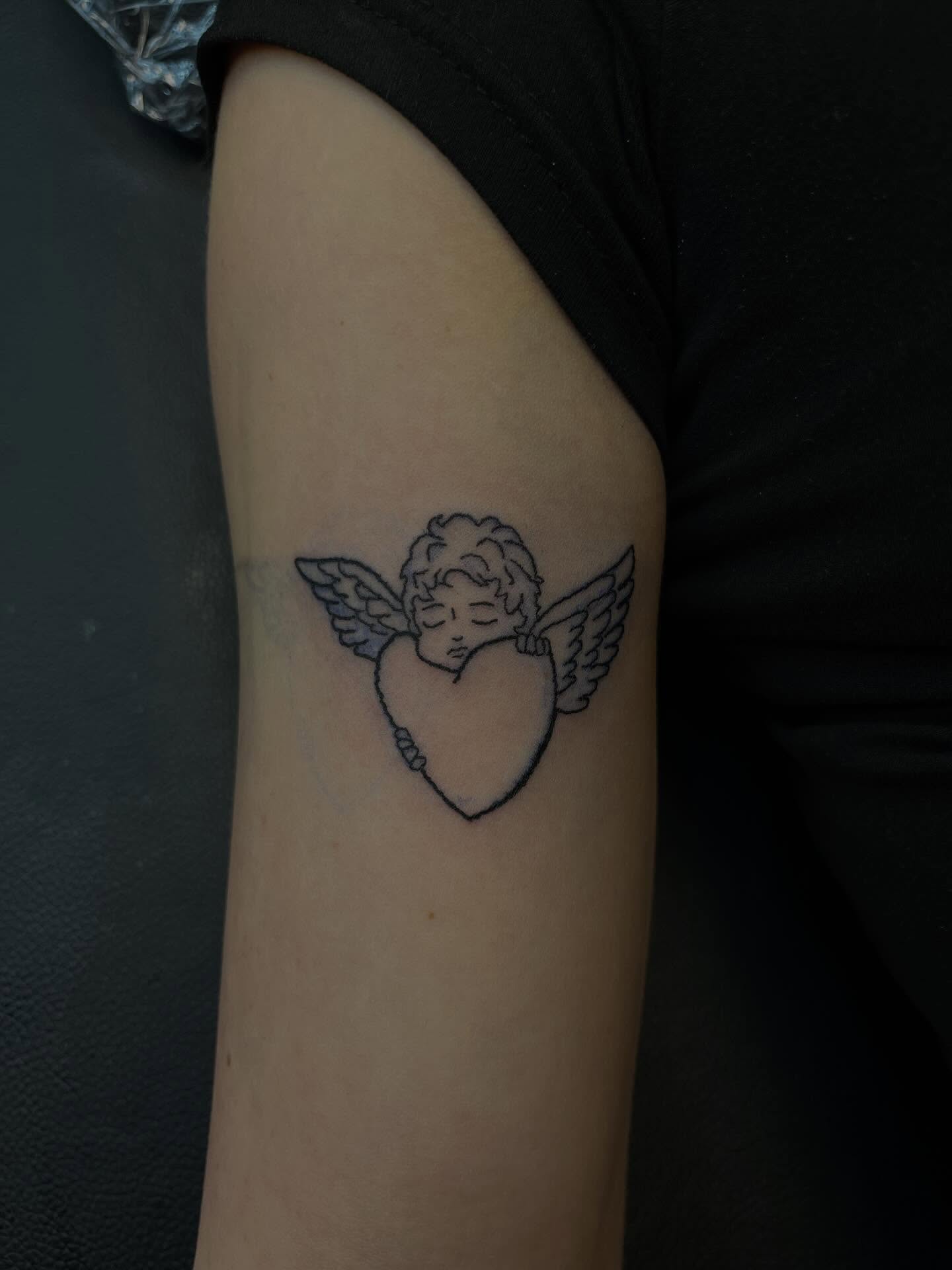 Heart with cherub black and grey tattoo on the forearm by XoXandrea.Ink, Kansas City, Missouri
