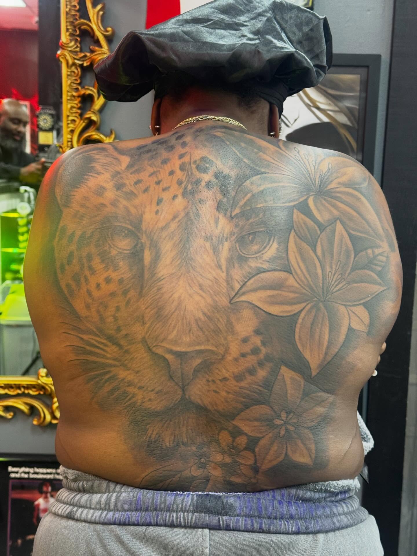 Leopard and flowers realism tattoo on the back by Alejandro Zaragoza