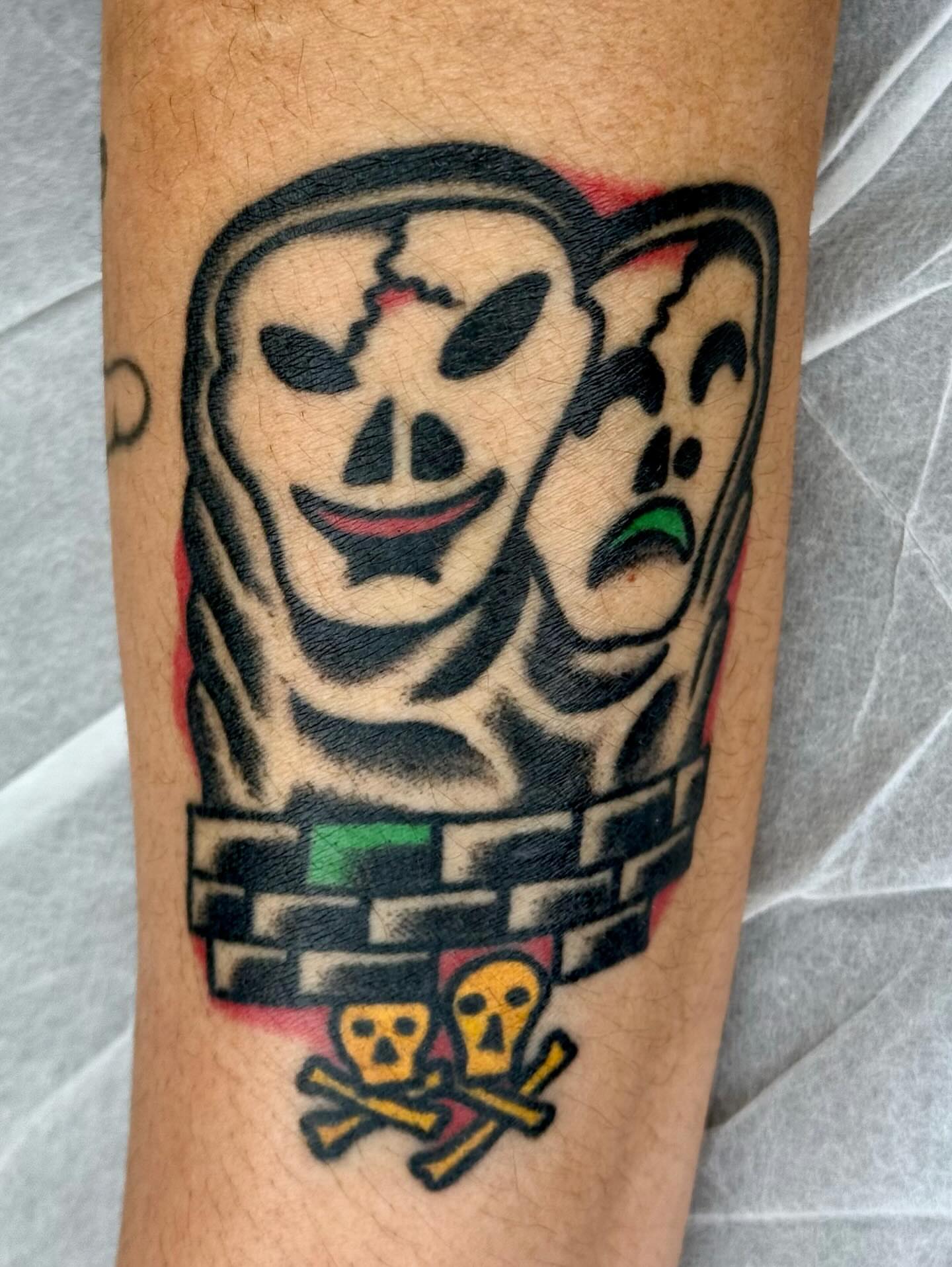 Jester mask American traditional tattoo on the forearm by JAX