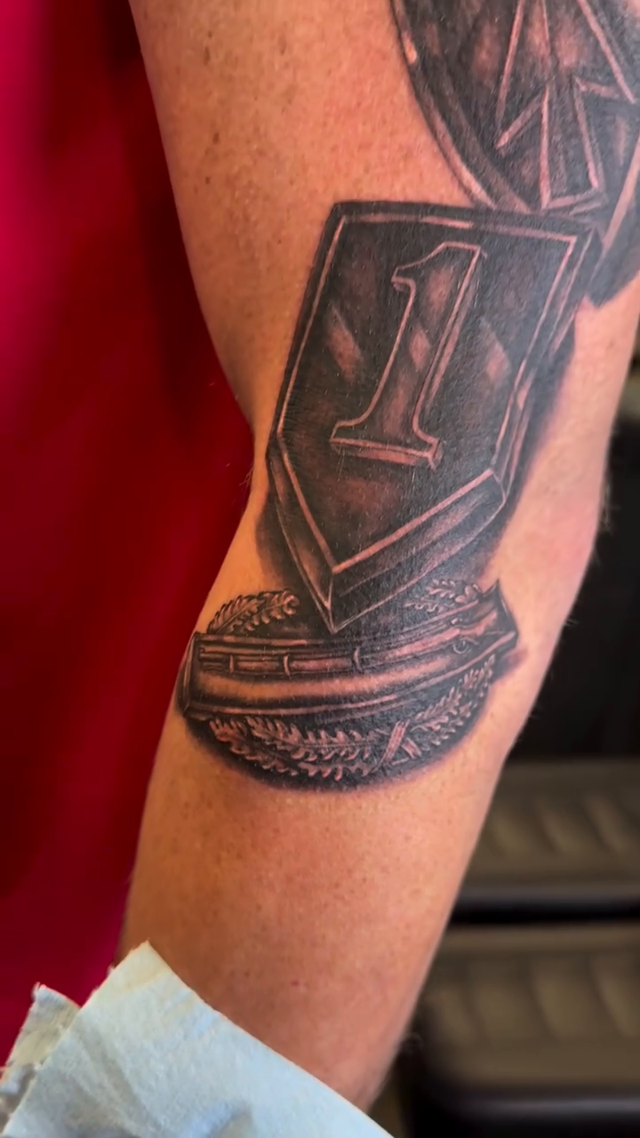 A trophy with the number 1 realism tattoo by Ricky Flemate, San Antonio