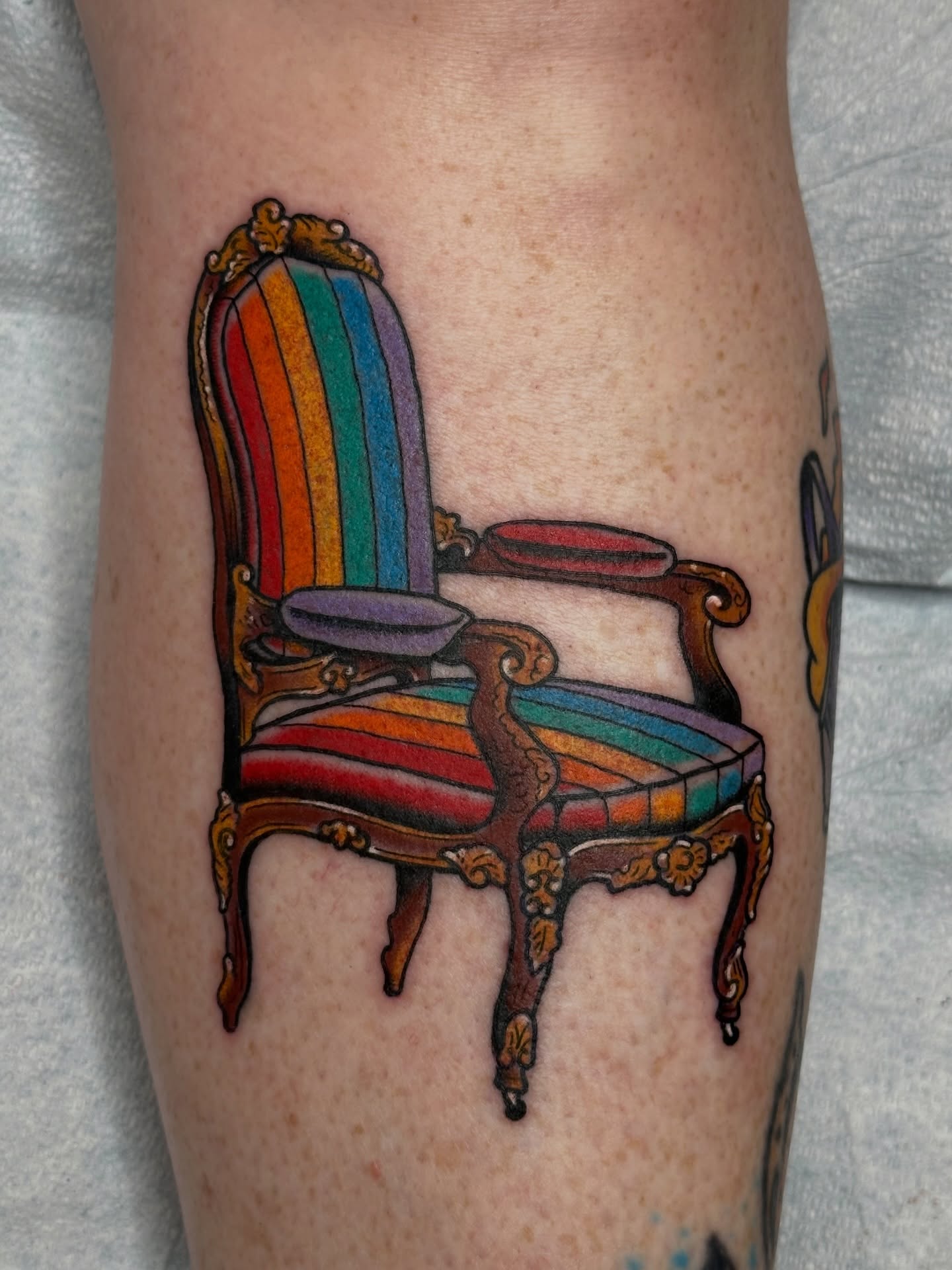Rainbow chair new school tattoo on the calf by Michael Williams