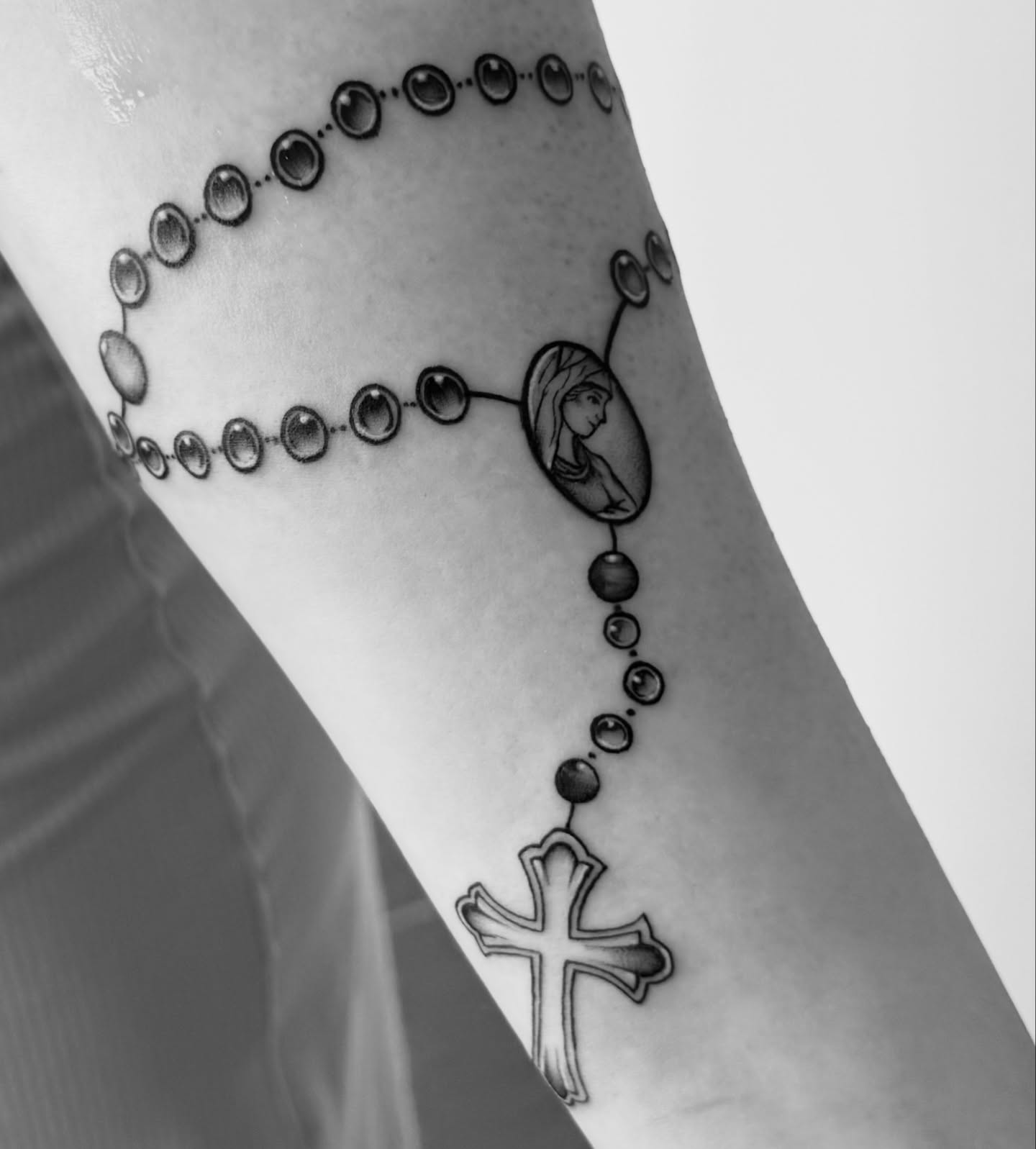 Rosary black and grey tattoo on the forearm by Lindsay Shriver