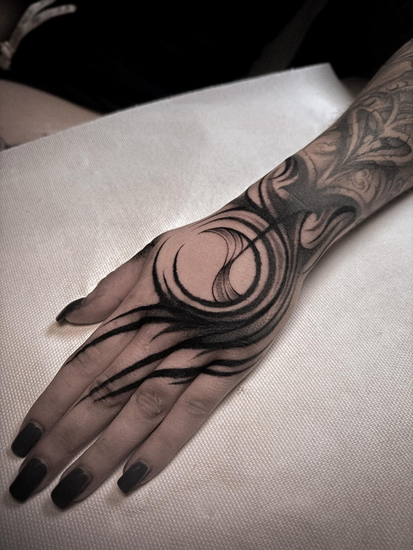 Abstract swirls black and grey tattoo on the hand by La Hyene