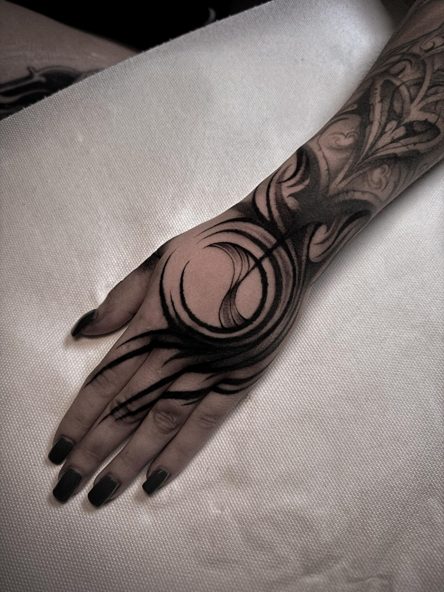 Abstract swirls black and grey tattoo on the hand by La Hyene