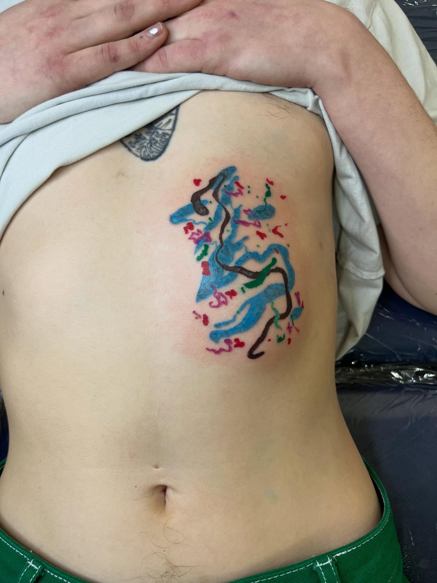 Abstract figure with hearts watercolor tattoo on the ribs by tattoos by quin