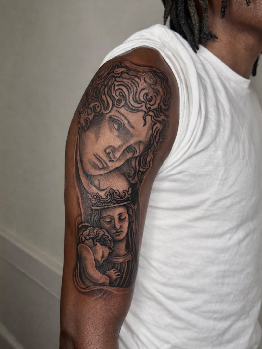 Religious figures Chicano tattoo on the upper arm by JayyeSosa