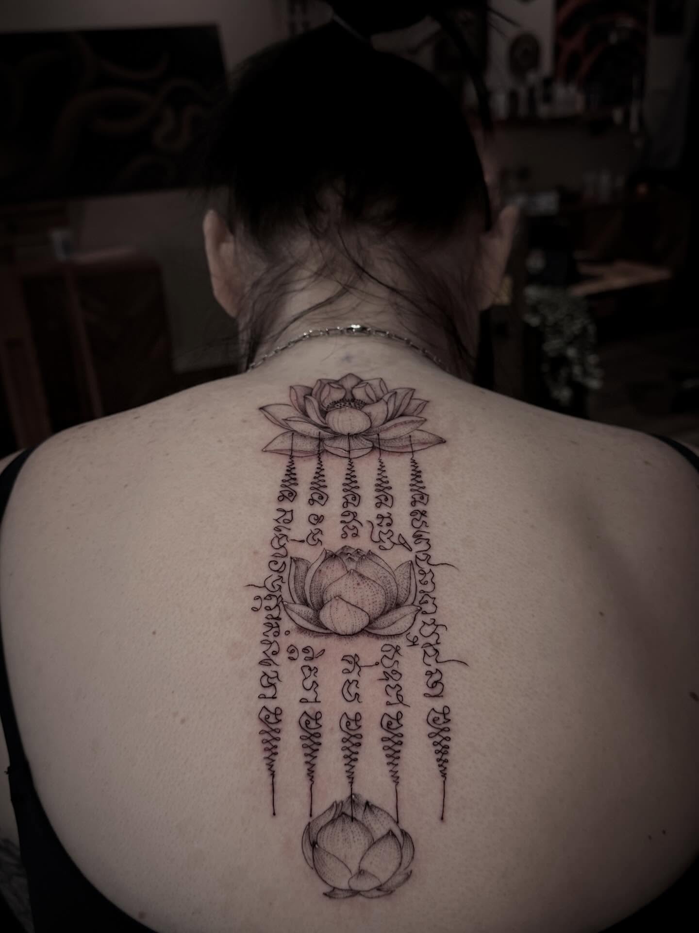 Lotus flowers and script black and grey tattoo on the back by Tattoos by Robyn Pallotta, Austin, Texas
