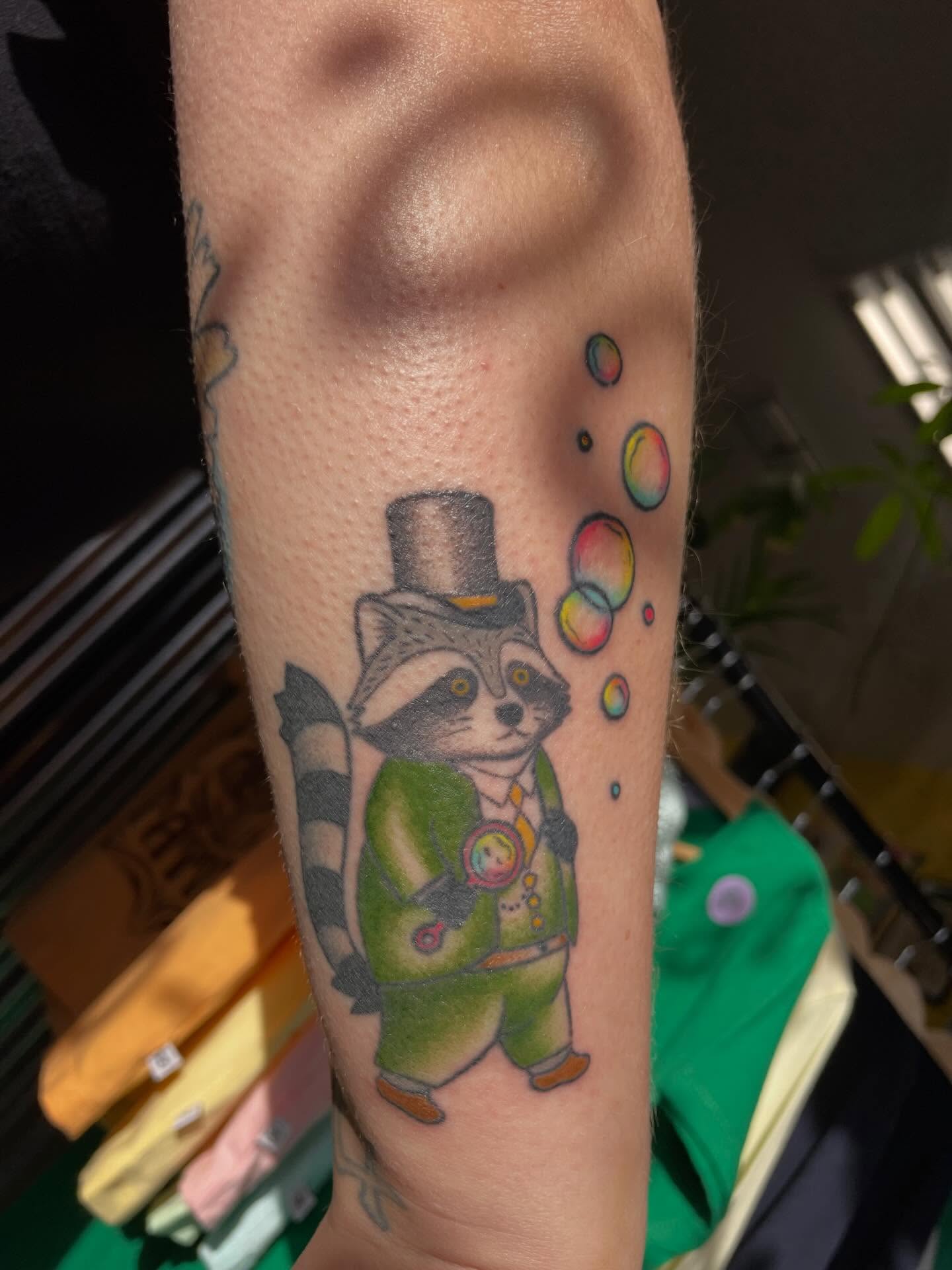 Raccoon magician new school tattoo on the forearm by Mallory Moore