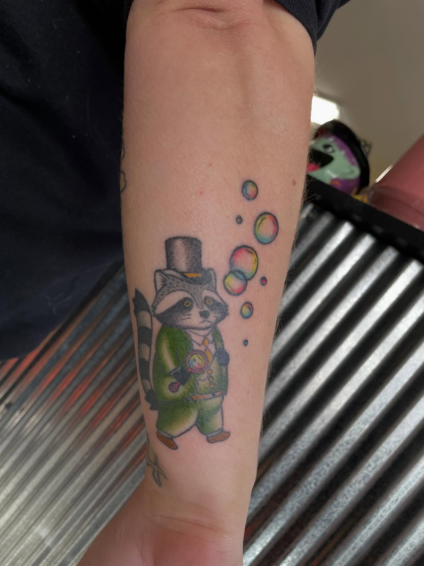 Raccoon new school tattoo on the forearm by Mallory Moore