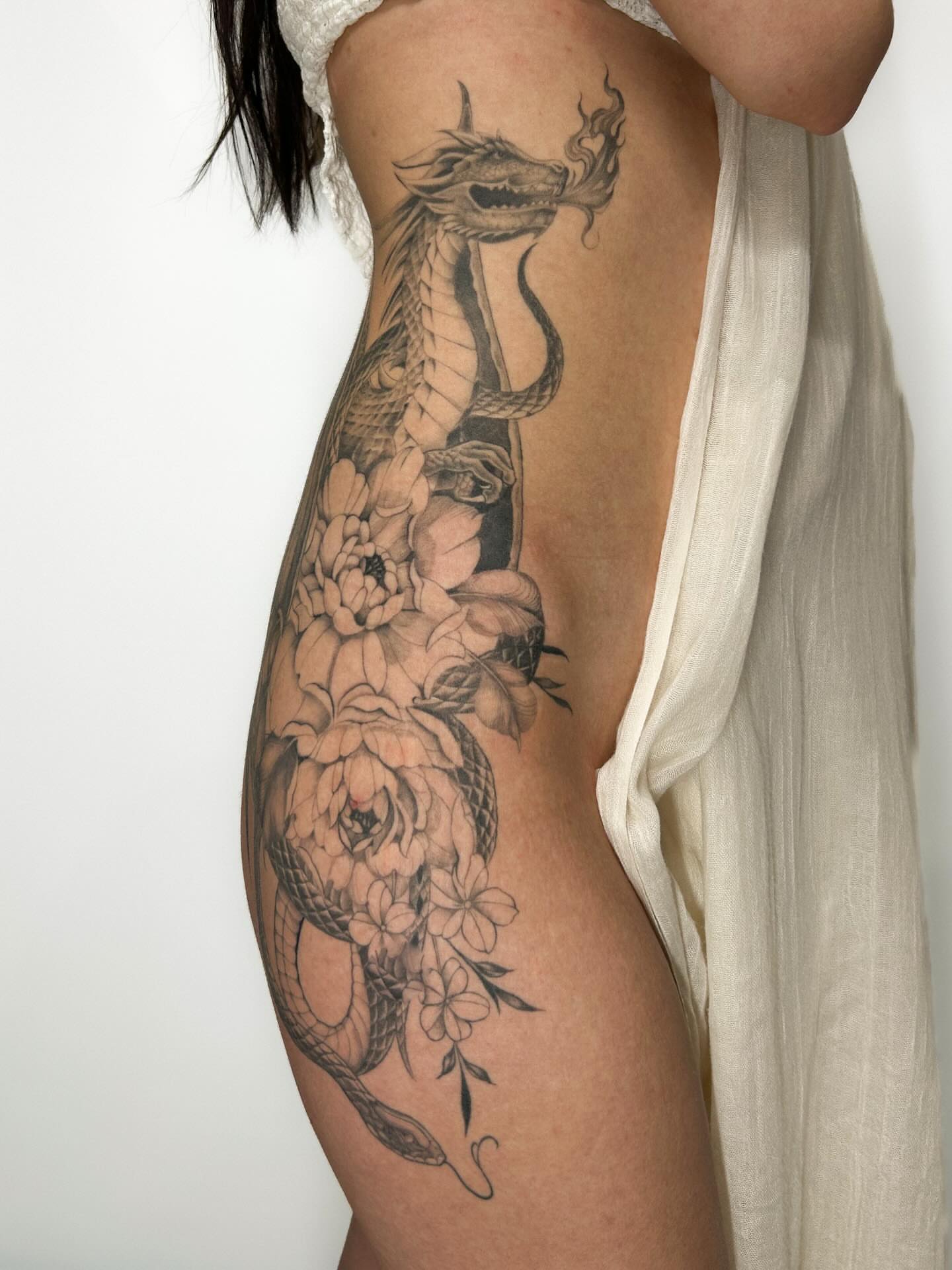 Dragon and flowers realism tattoo on the ribs by Chloe