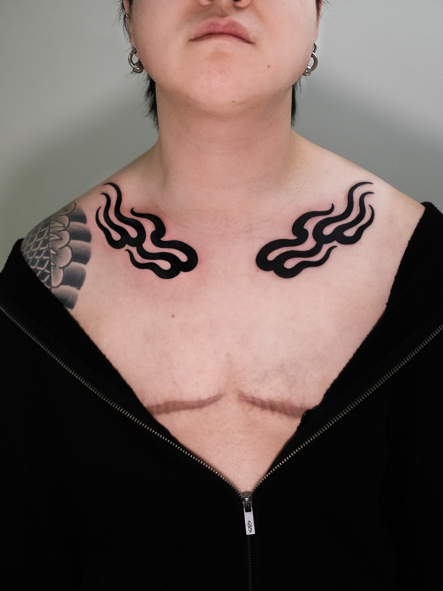Flame black and grey tattoo on the chest by seattle tattoo artist