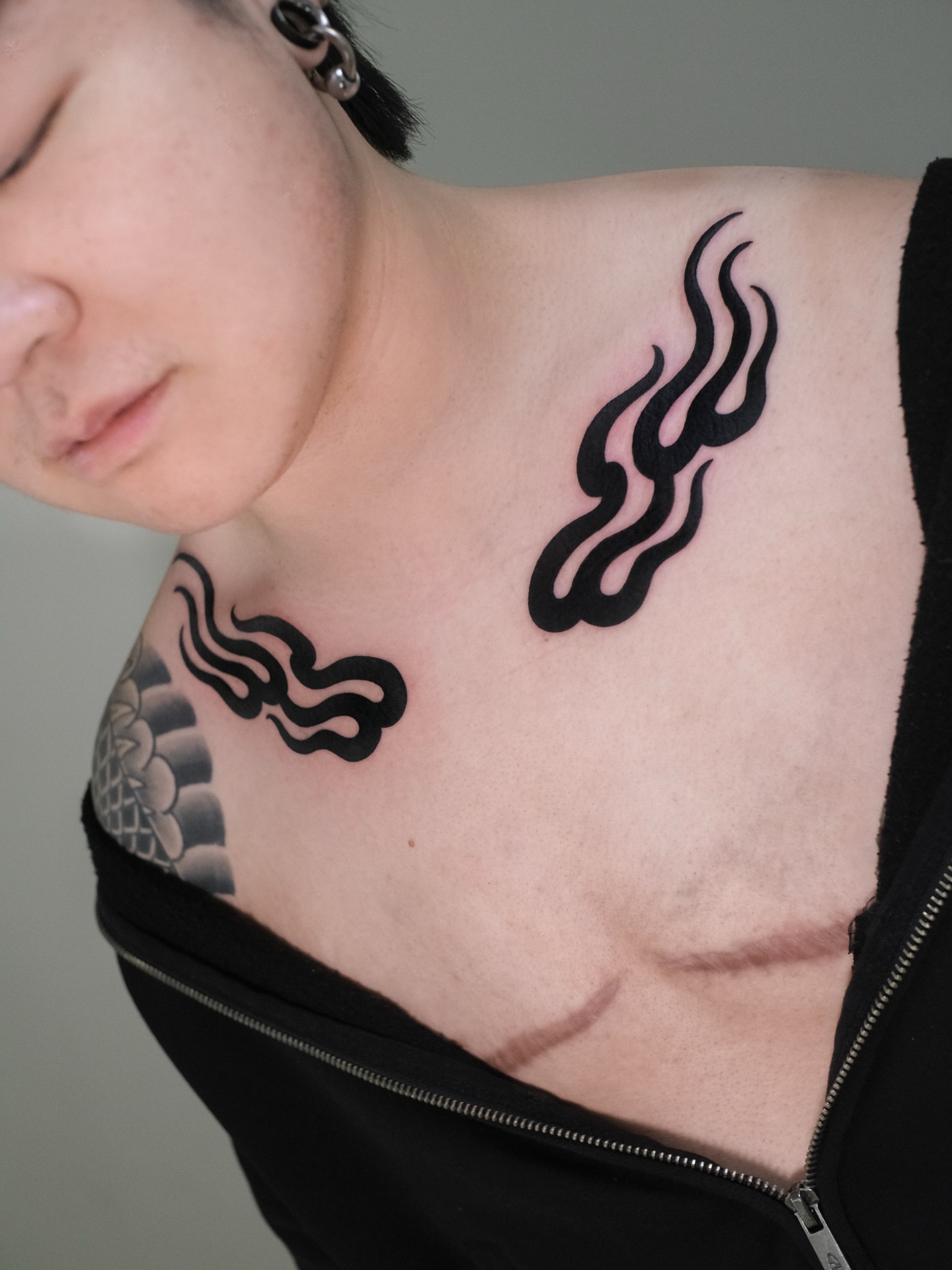 Flame black and grey tattoo on the chest by seattle tattoo artist