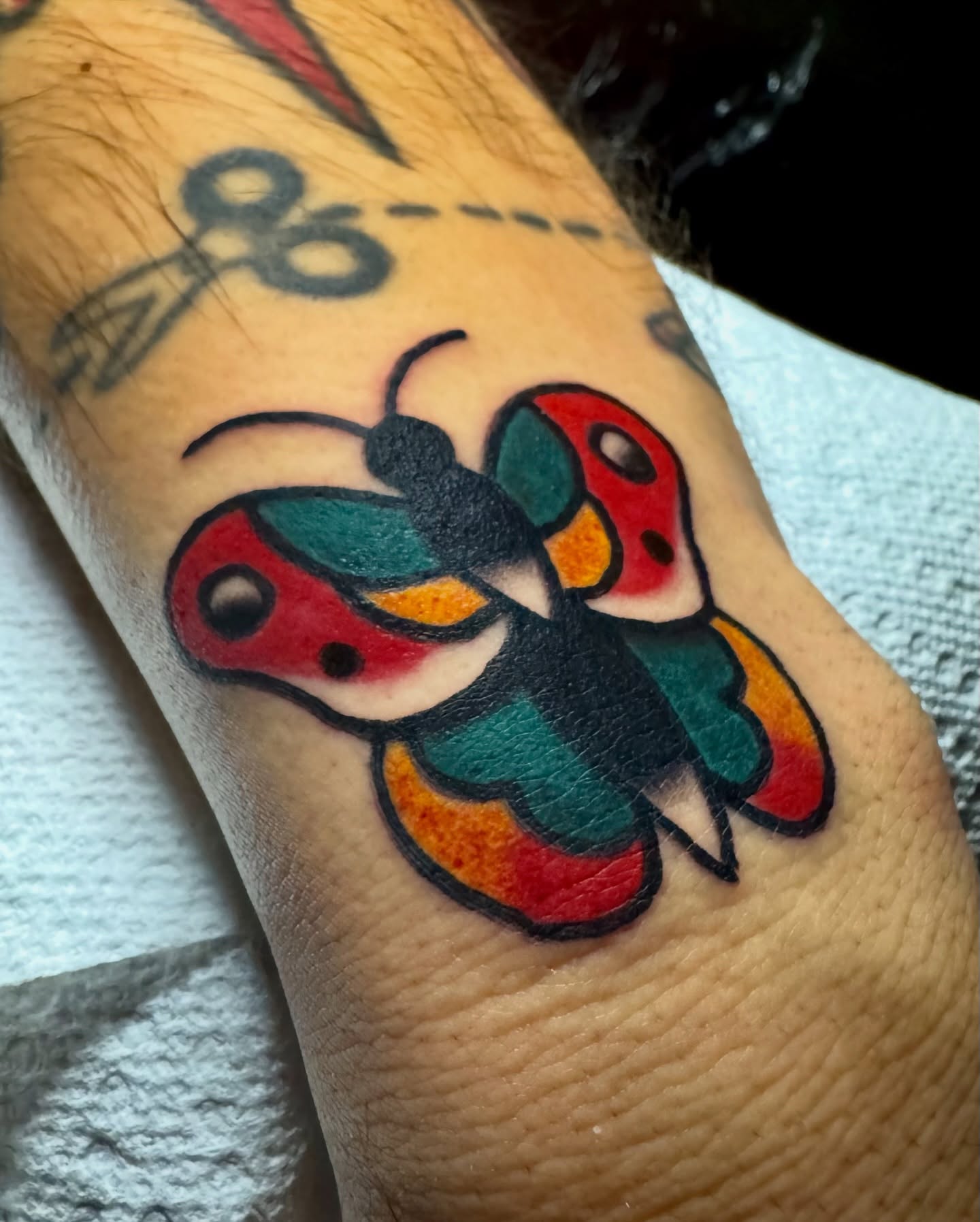 Ladybug American traditional tattoo on the forearm by Javin Klingelhoefer Mosley