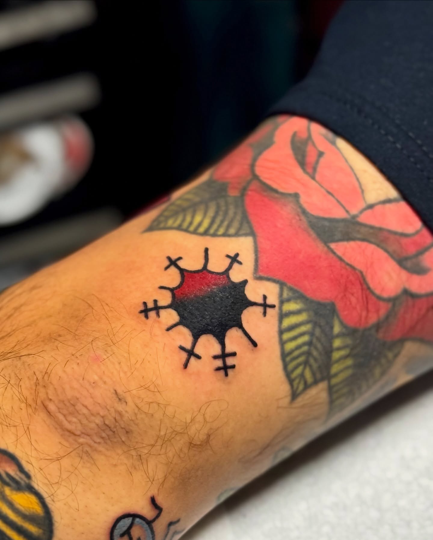 Crossed-out heart trash polka tattoo on the forearm by Javin Klingelhoefer Mosley