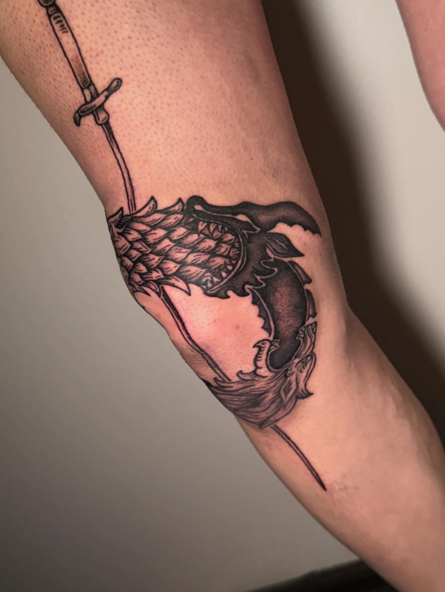 Dragon and sword black and grey tattoo on the forearm by Katie Rojas