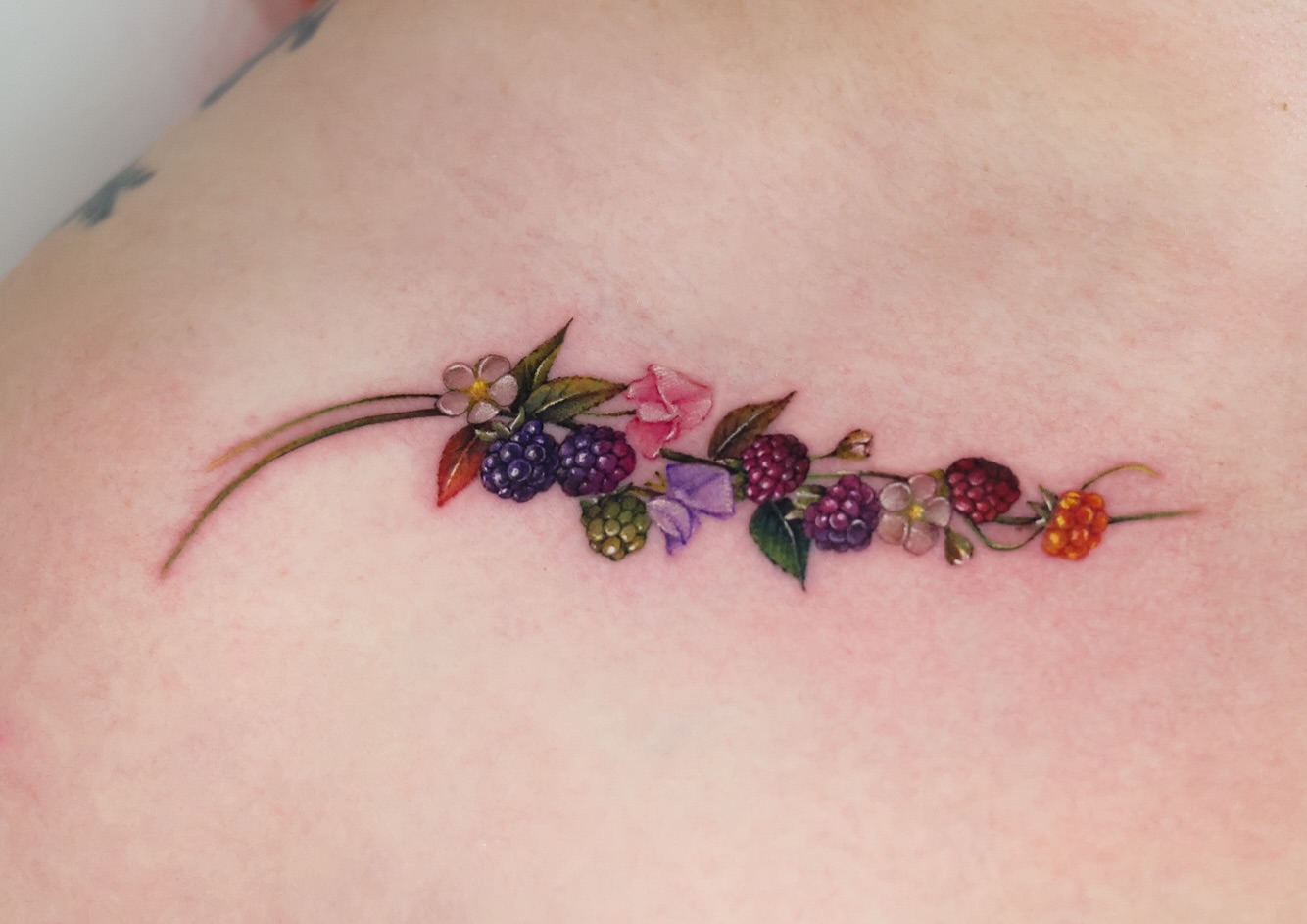 Berry and flower bouquet realism tattoo on the shoulder by 𝒀𝒖𝒏𝒎𝒊 𝑷𝒂𝒓𝒌