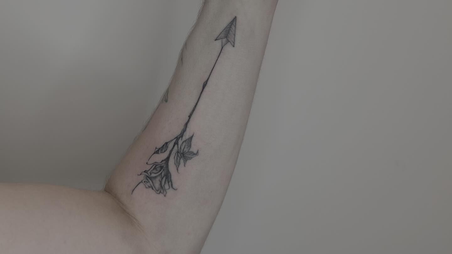 Arrow piercing rose black and grey tattoo on the forearm by Van Cleave Aesthetics, Franklin, Tennessee