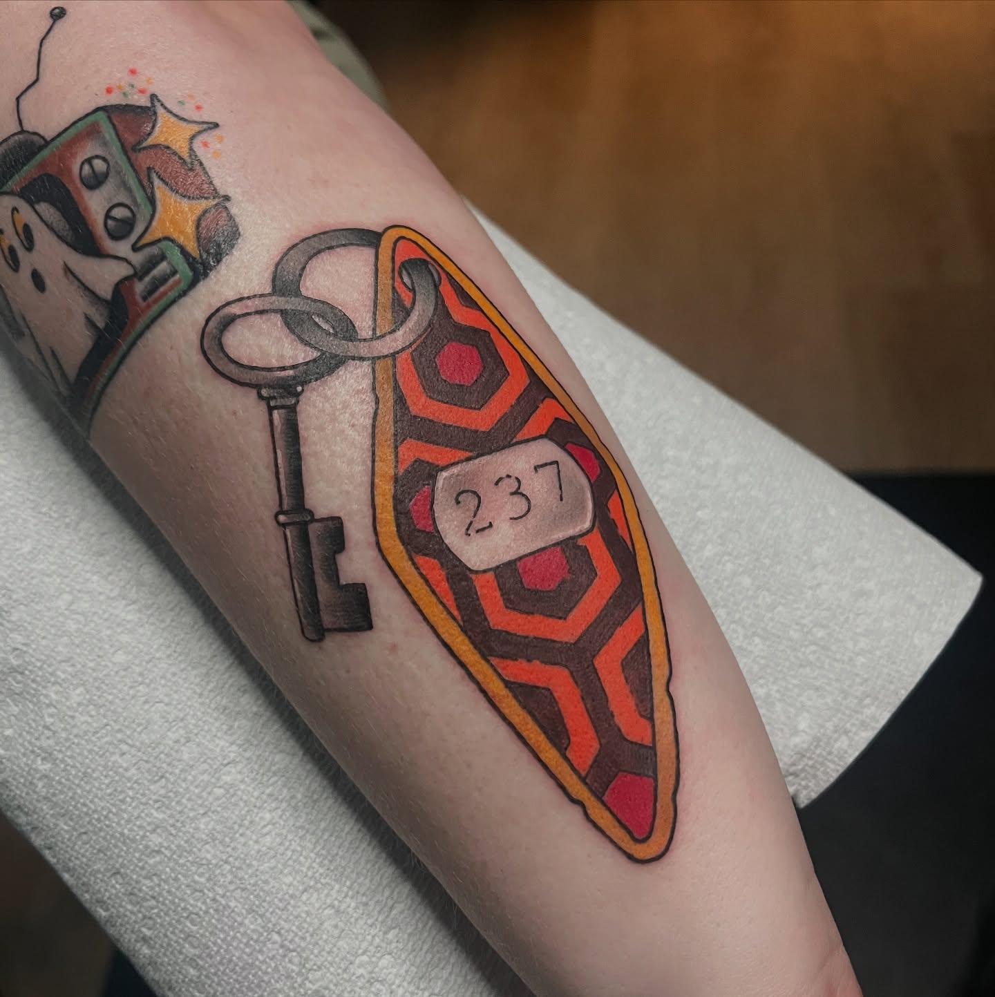 Key and shield geometric tattoo on the forearm by Timmy
