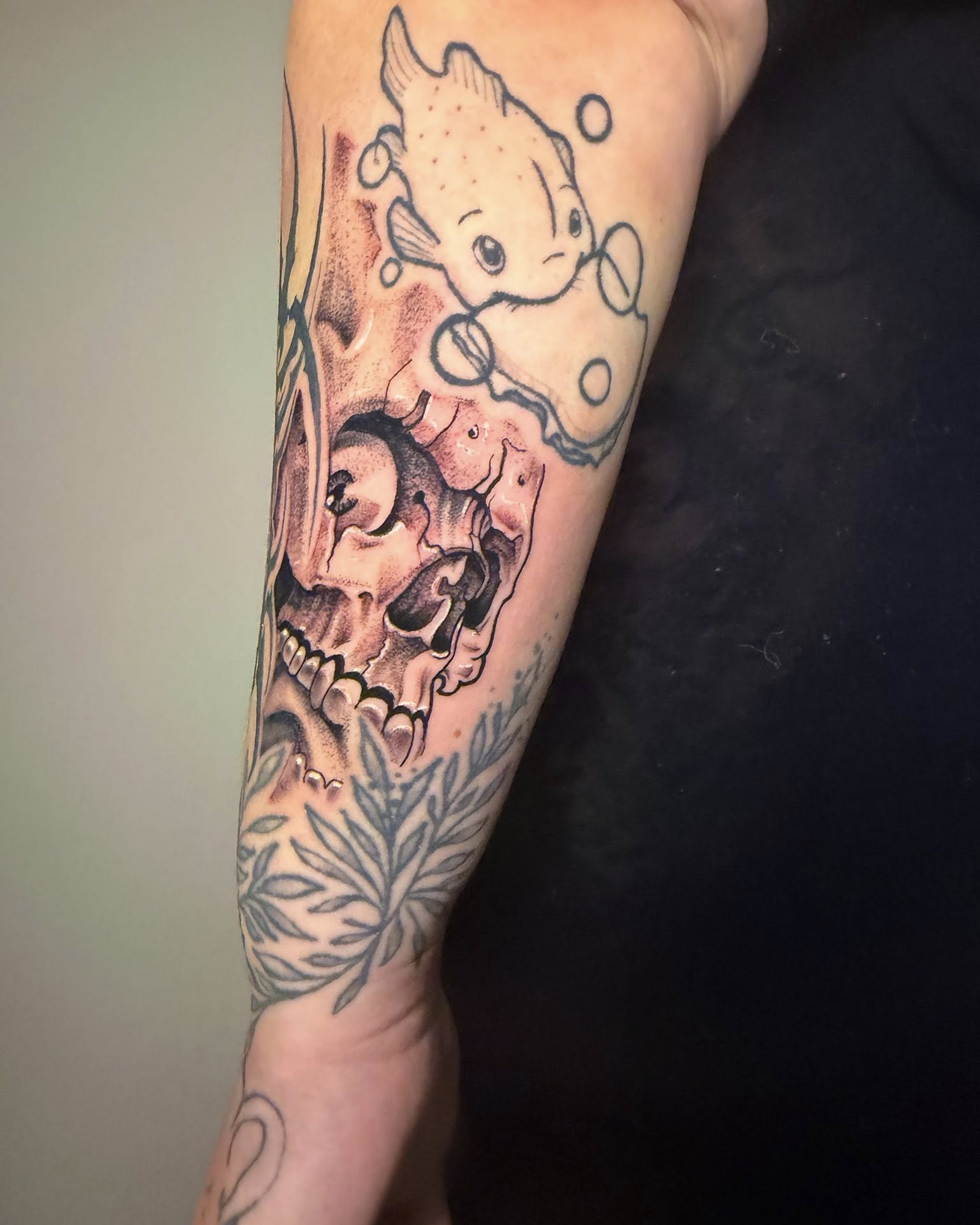 Skull and fish American traditional tattoo on the forearm by Haley Winfree