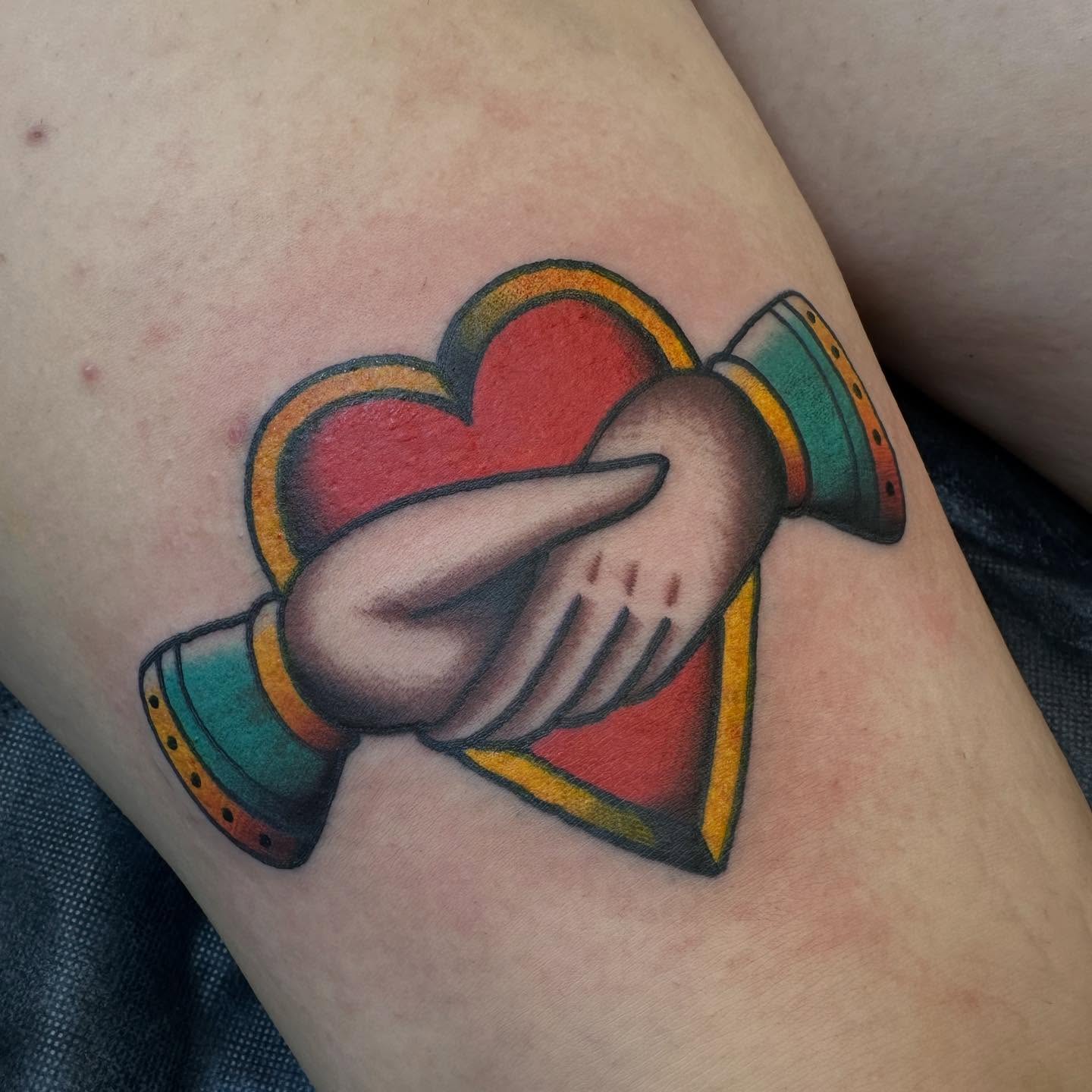 Heart and hands American traditional tattoo on the thigh by Hannah Jean