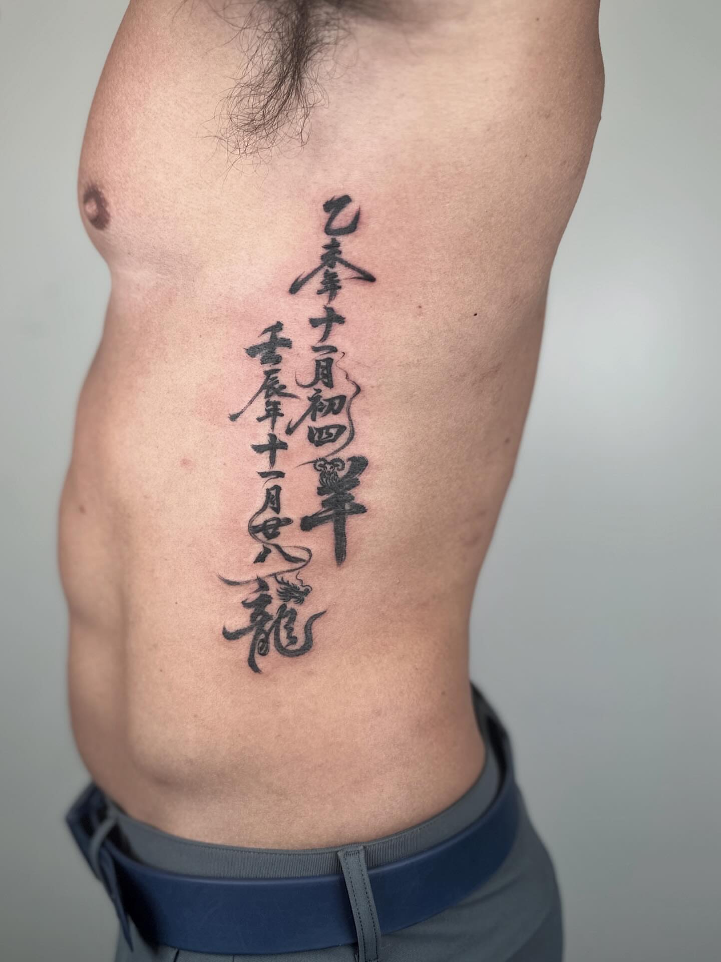 Calligraphy lettering script tattoo on the ribs by Jiang_Tattooer